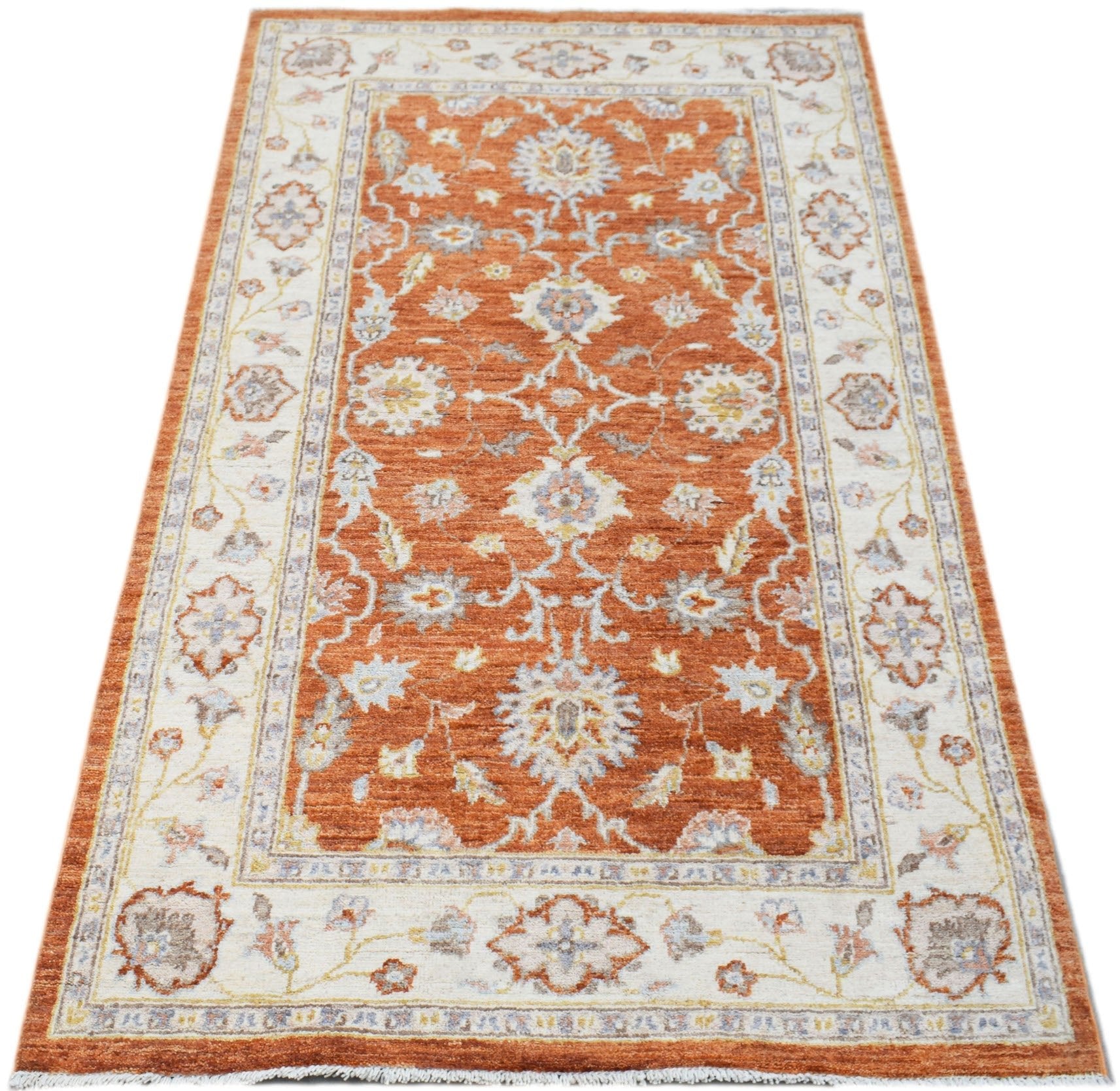 An Afghan Chobi rug featuring a traditional floral pattern in shades of orange and cream.