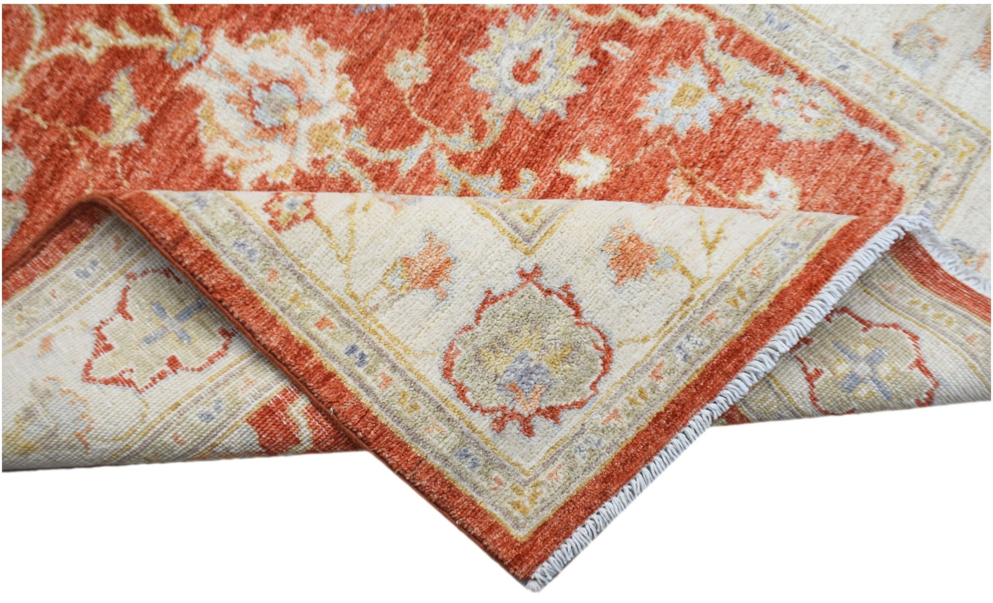 A handwoven Afghan Chobi rug featuring a traditional floral pattern in rust and cream tones.