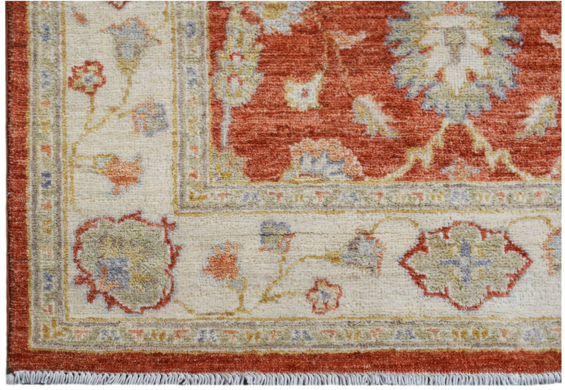 A handmade Afghan Chobi rug featuring a traditional floral pattern in rust, cream, and sage tones.