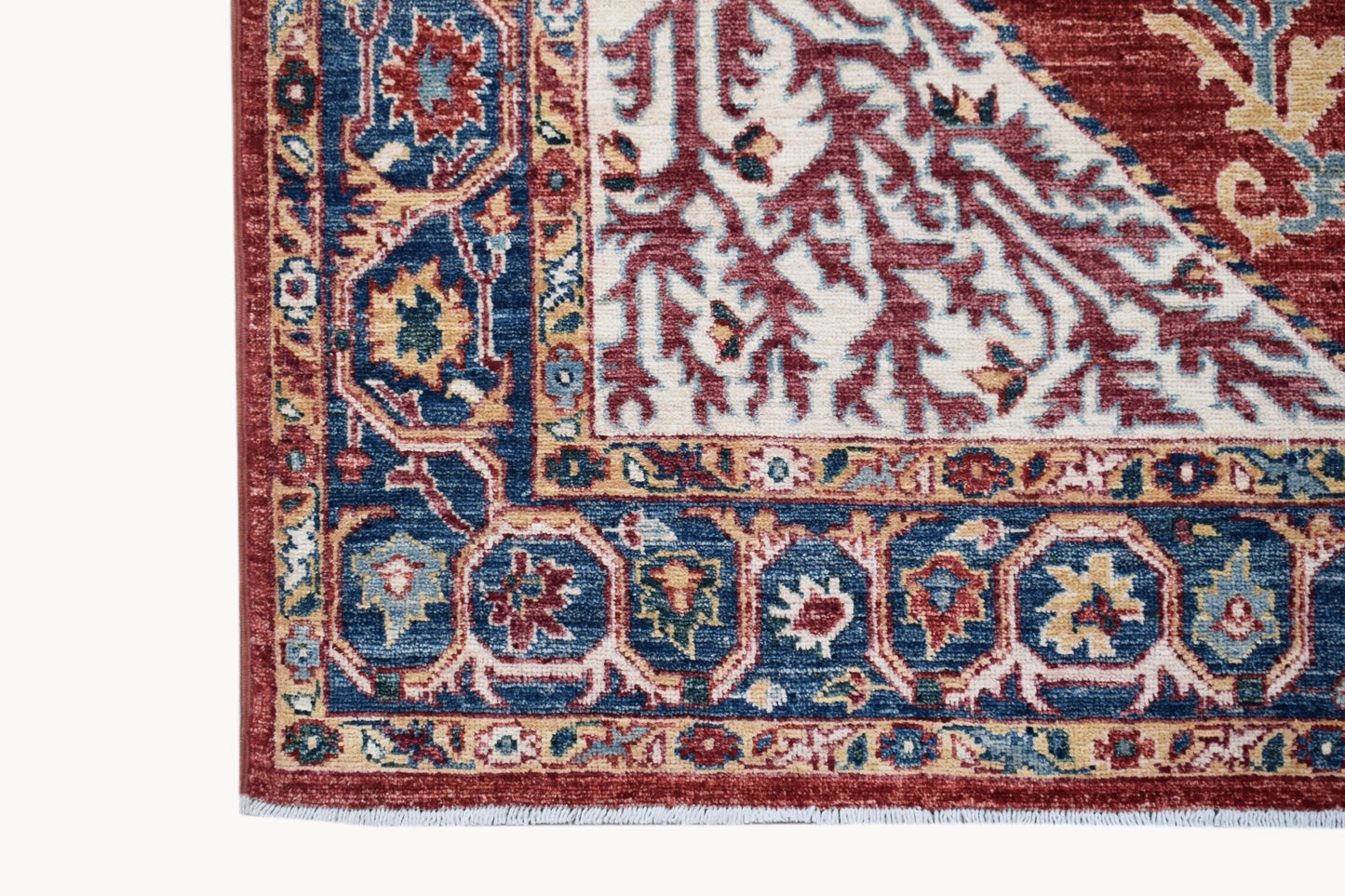 A handmade Afghan Chobi rug featuring a traditional Heriz pattern in red, blue, and cream tones.