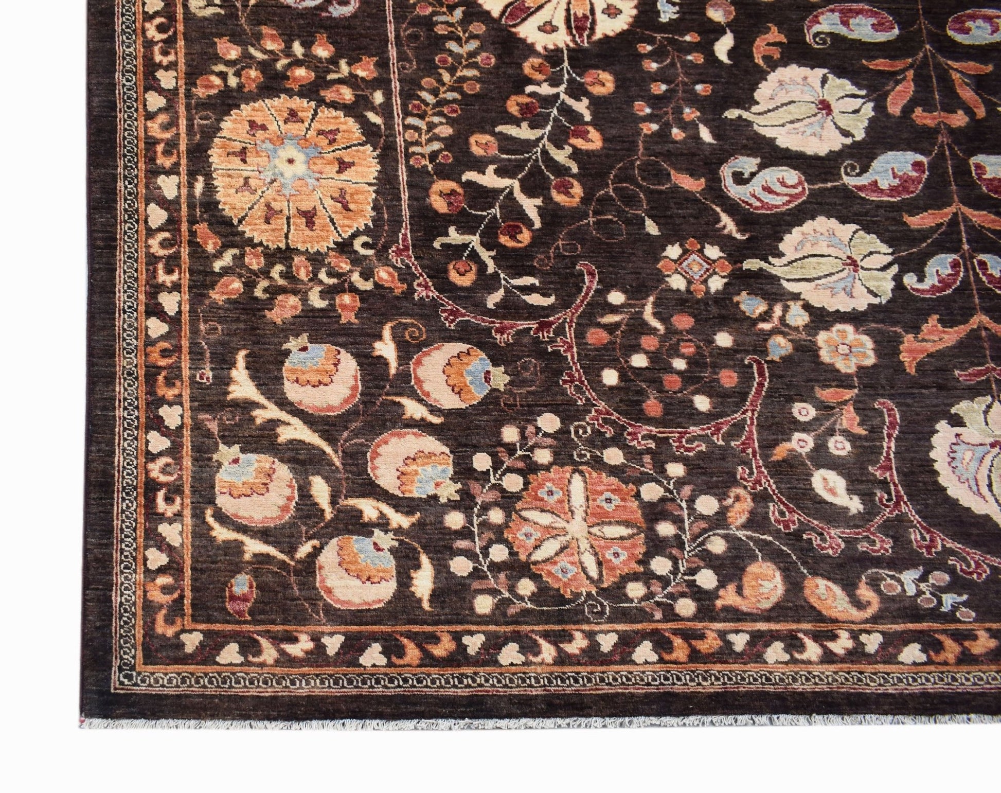 A handmade Afghan Chobi rug featuring a dark brown field with intricate floral and vine patterns.