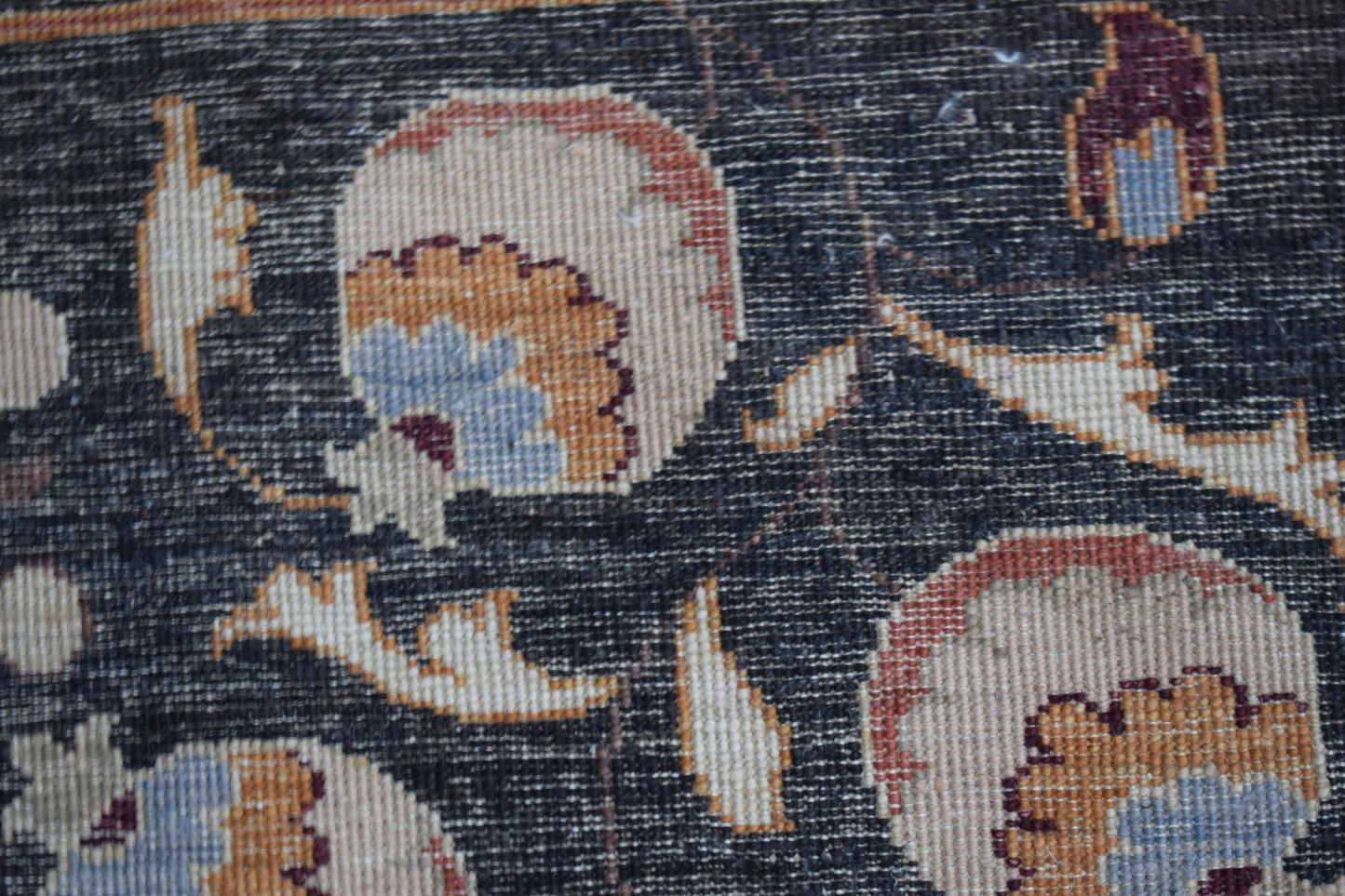 A close-up of a handmade Afghan Chobi rug featuring intricate floral patterns in earthy tones.