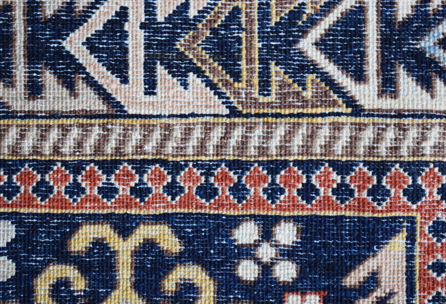 A close-up of a handwoven Afghan Chobi rug featuring intricate geometric and floral patterns.