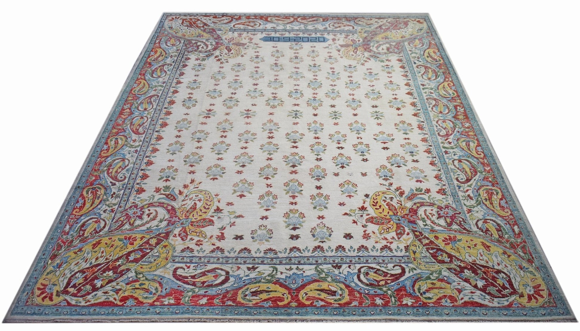 An Afghan Chobi rug featuring a cream field with floral motifs and a colorful paisley border.