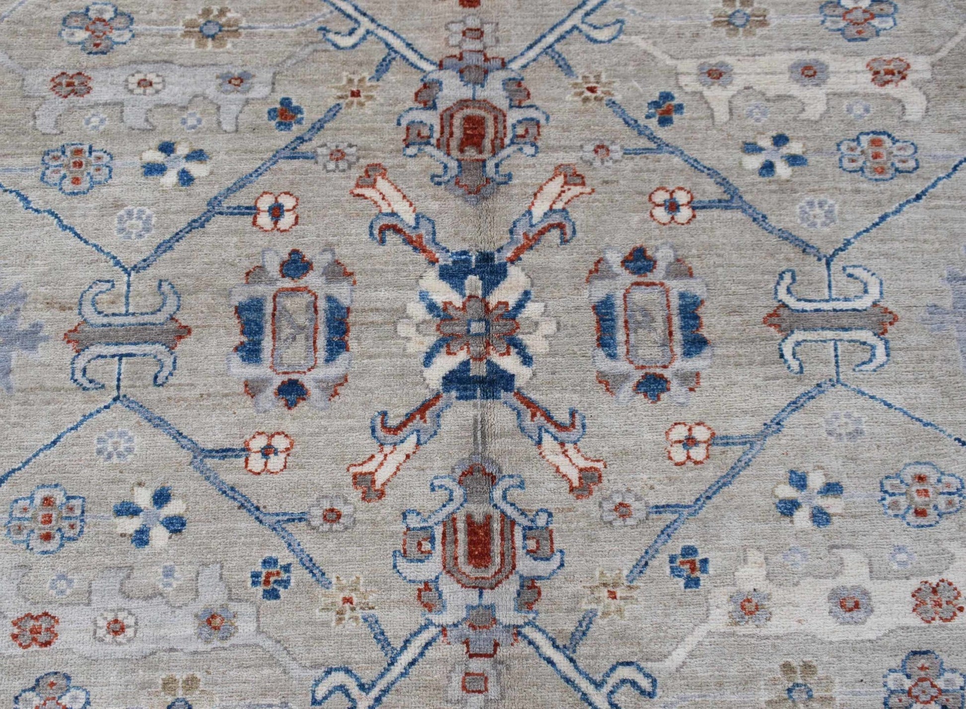 Handwoven Afghan Chobi rug featuring a traditional floral pattern in blue, red, and beige tones.