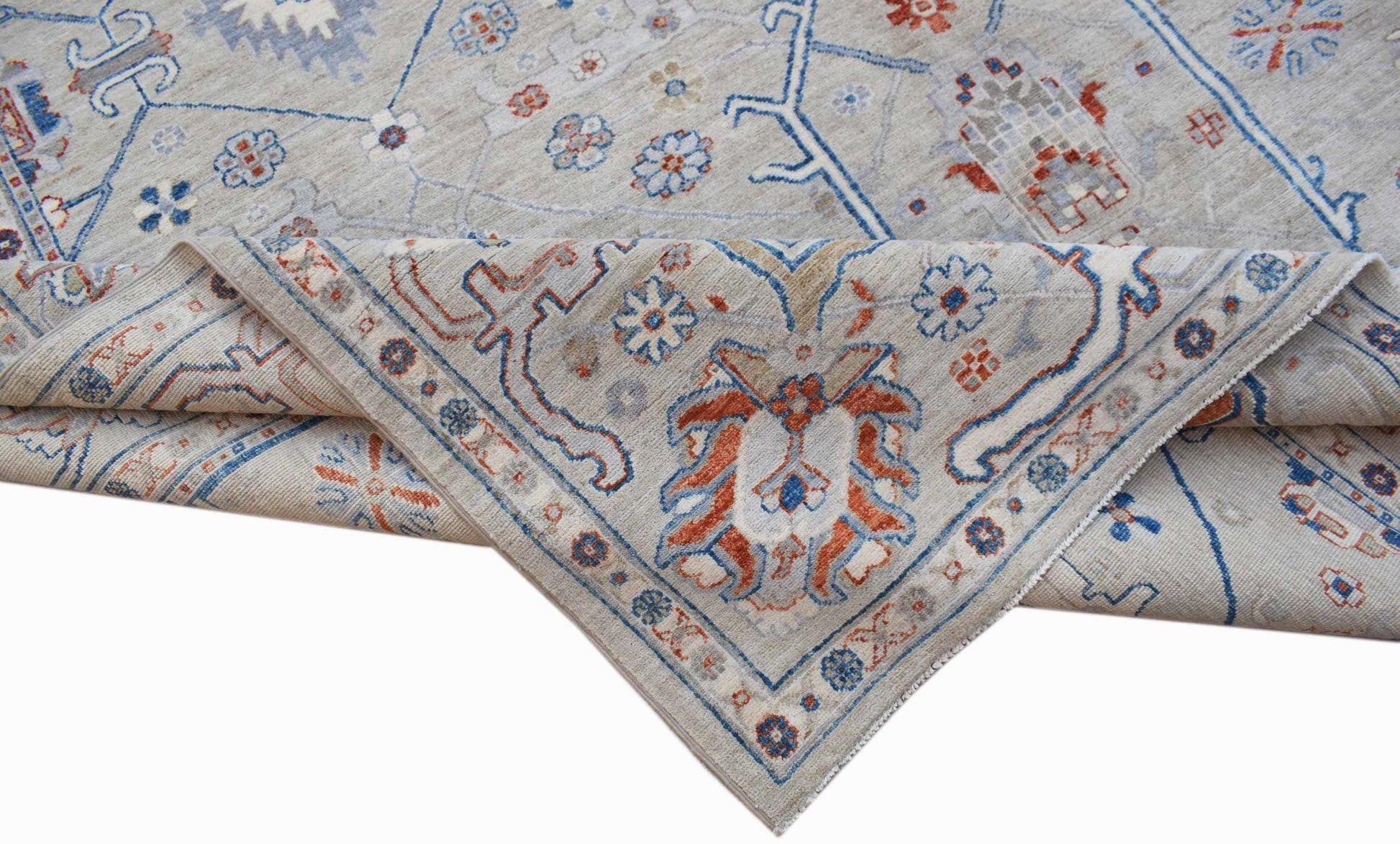 A handwoven Afghan Chobi rug featuring a light grey field with blue and rust floral patterns.