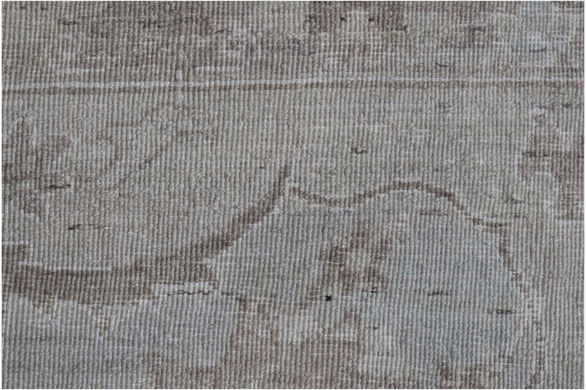 A close-up of a handwoven Afghan Balkh rug featuring a neutral, distressed floral pattern.