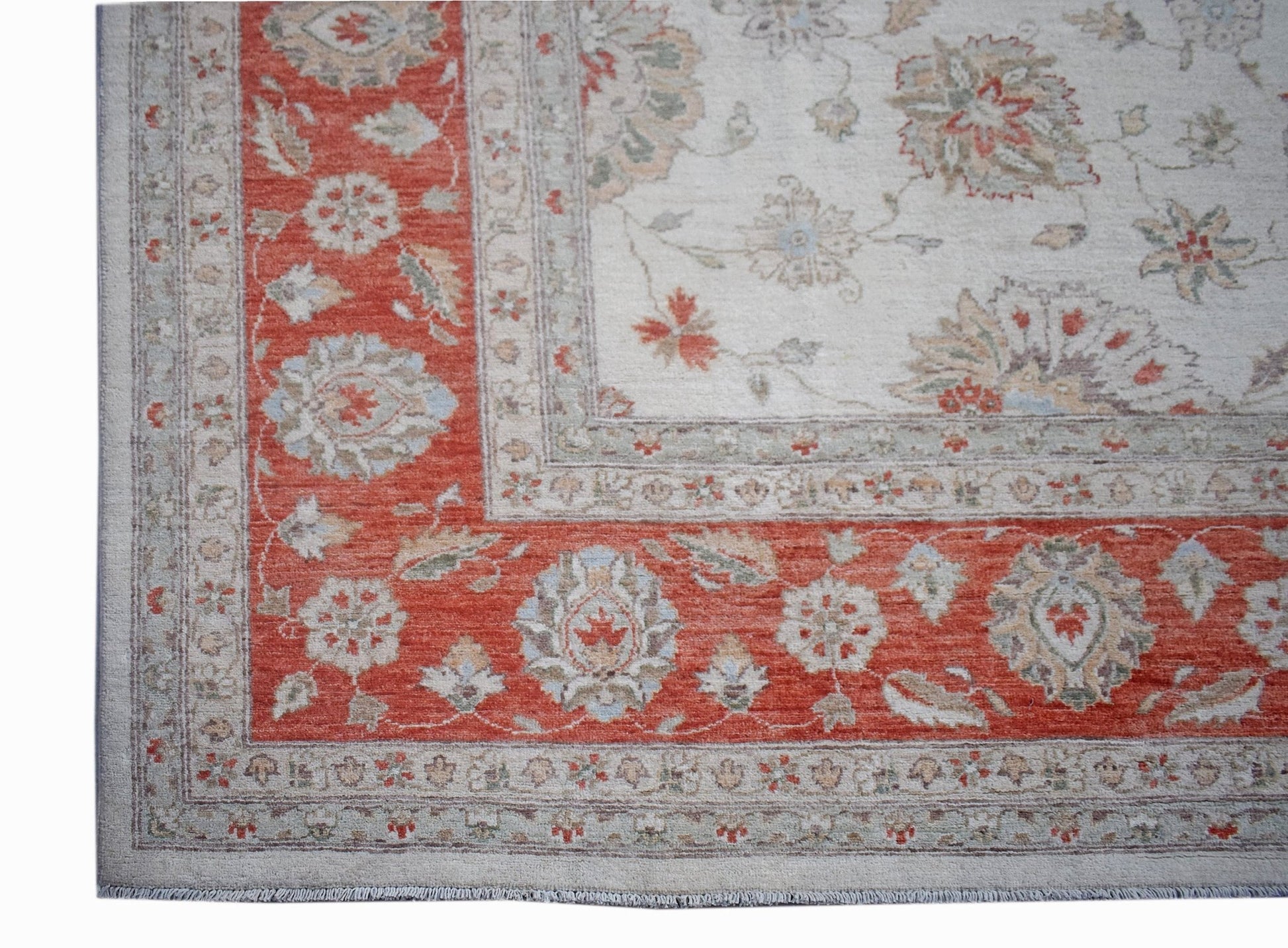 A handmade Afghan Chobi rug featuring a traditional floral pattern in red and cream tones.