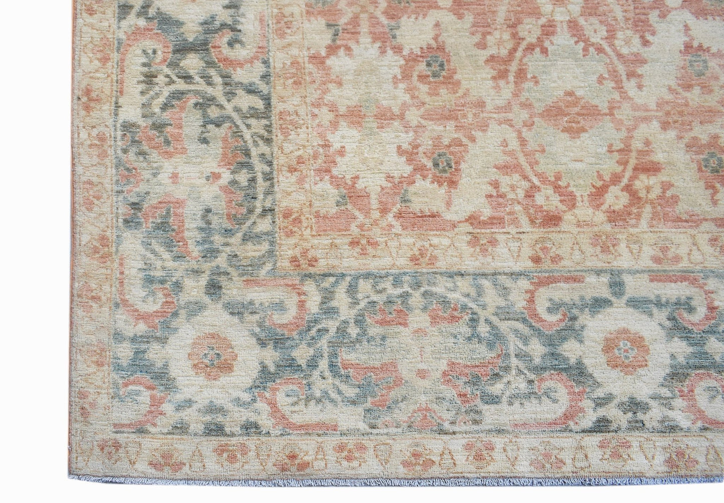 A handmade Afghan Balkh rug featuring a traditional floral pattern in muted peach and blue tones.