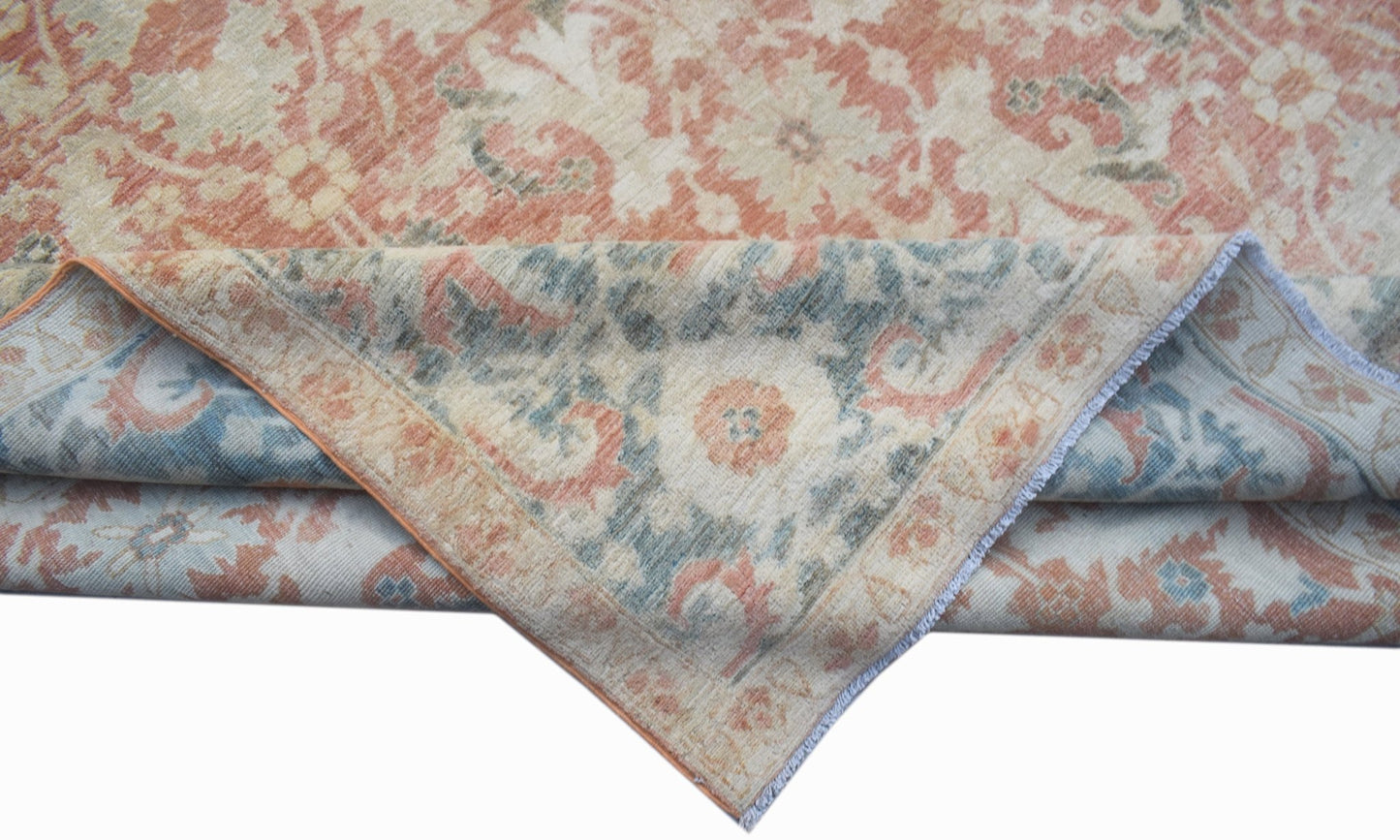 A handwoven Afghan Balkh rug featuring a traditional floral pattern in muted orange and blue tones.