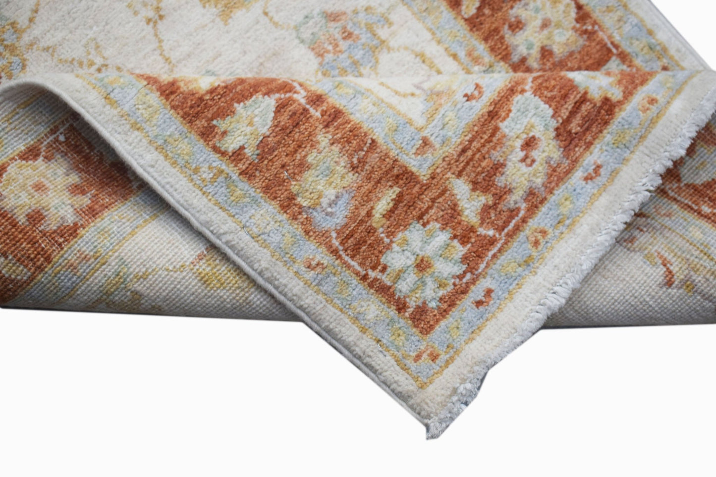 A handwoven Afghan Chobi runner featuring a traditional floral pattern in rust and cream tones.