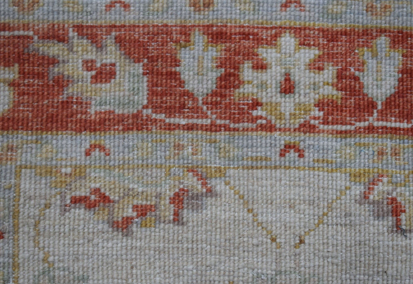 A close-up of an Afghan Chobi runner featuring traditional floral patterns in rust and cream tones.