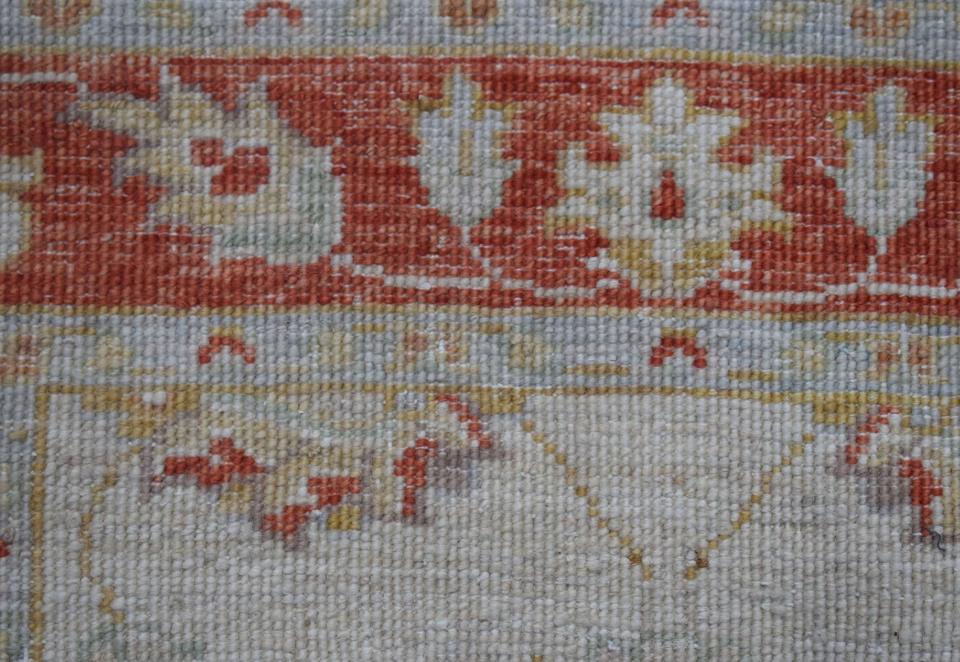 A close-up of an Afghan Chobi runner featuring traditional floral patterns in rust and cream tones.