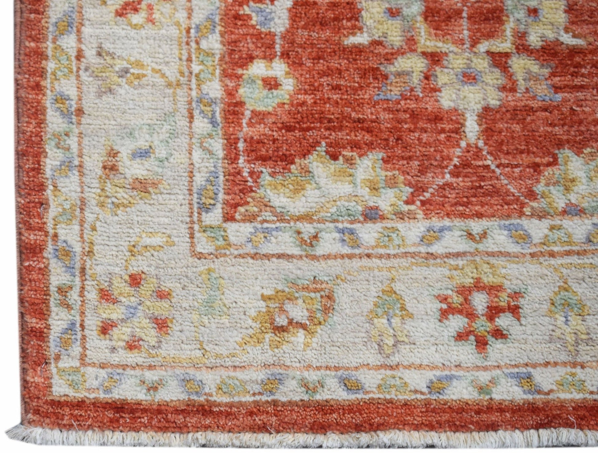 A handmade Afghan Chobi runner featuring a traditional floral pattern in rust and cream tones.