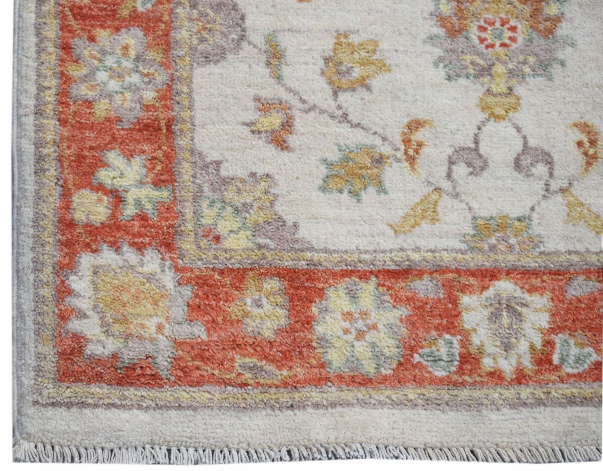 A handmade Afghan Chobi runner featuring a floral pattern in orange, yellow, and cream tones.