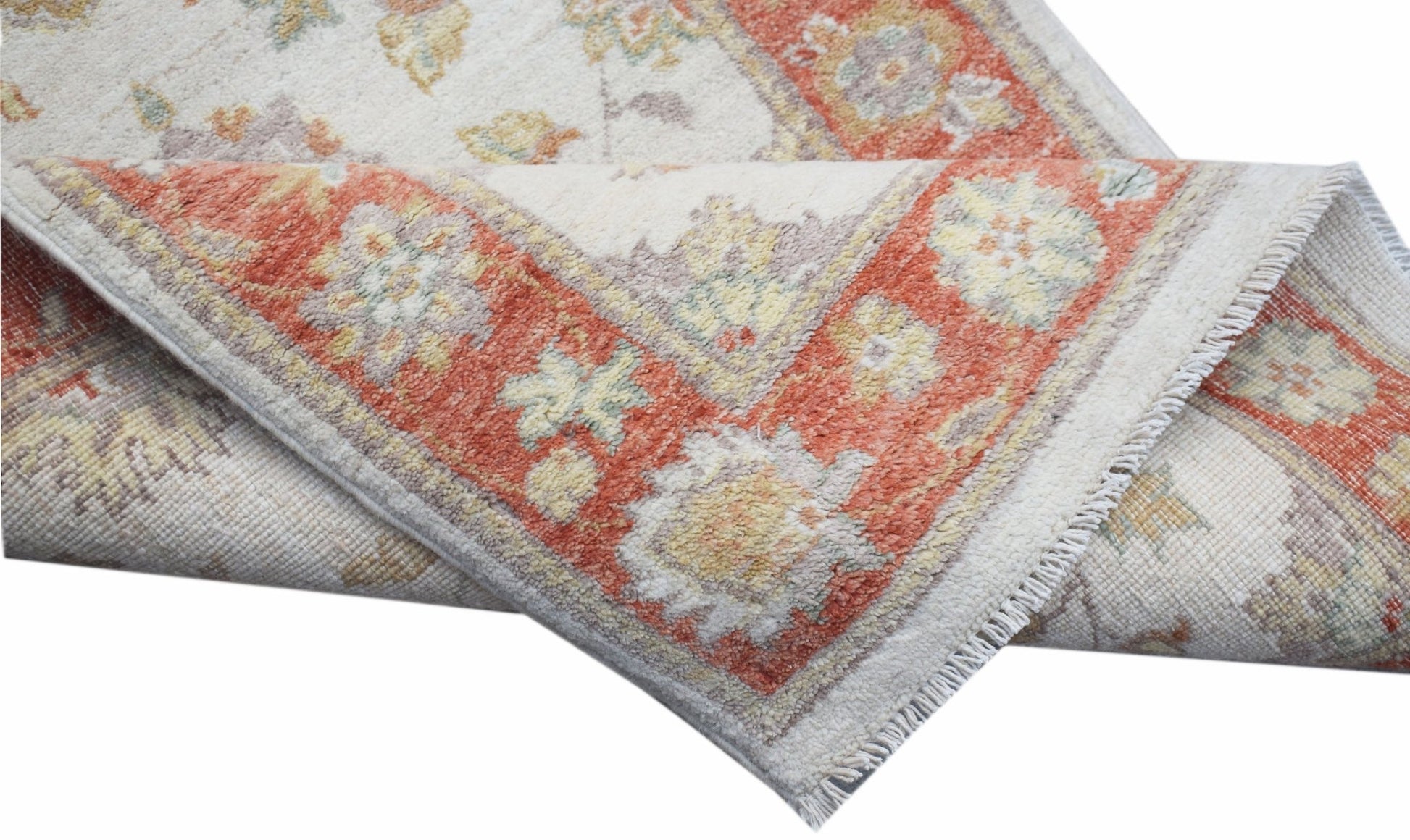 A handwoven Afghan Chobi runner featuring a traditional floral pattern in orange and cream tones.