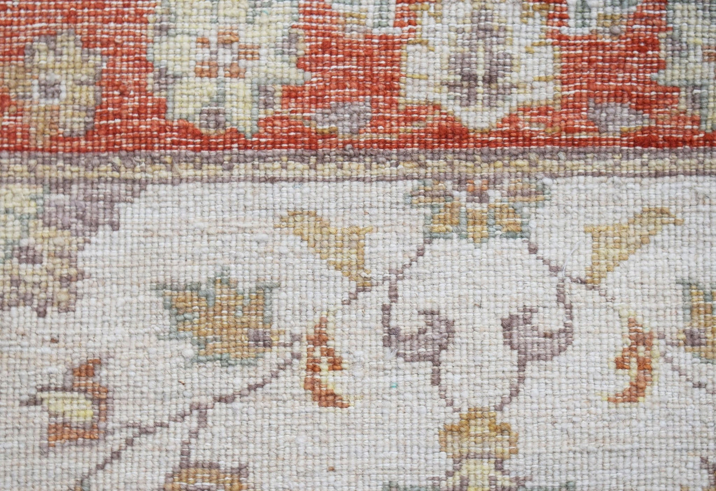 A close-up of a handwoven Afghan Chobi runner featuring traditional floral patterns in earthy tones.