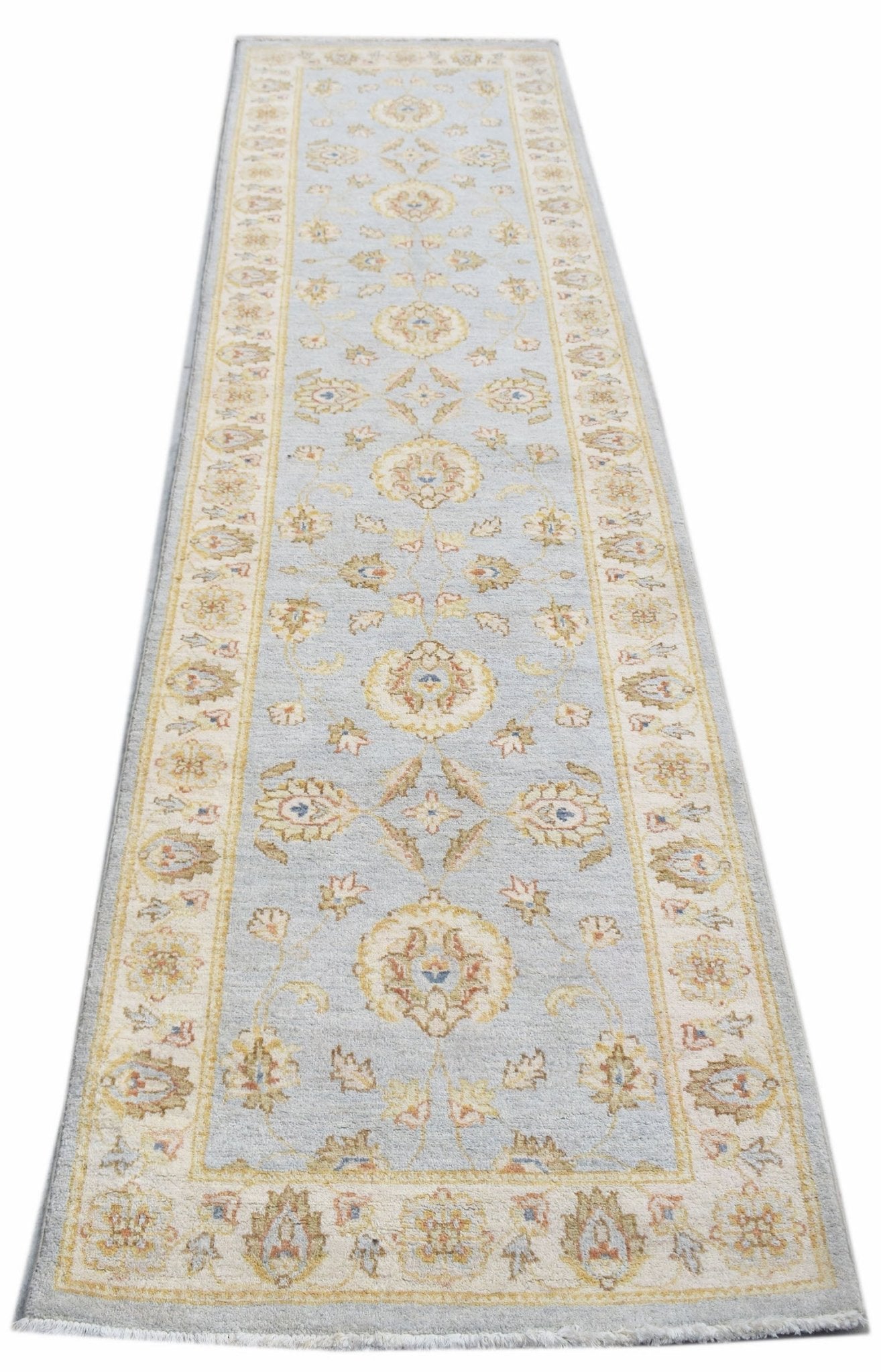 A handwoven Afghan Chobi runner rug featuring a traditional floral pattern in soft blue and cream.