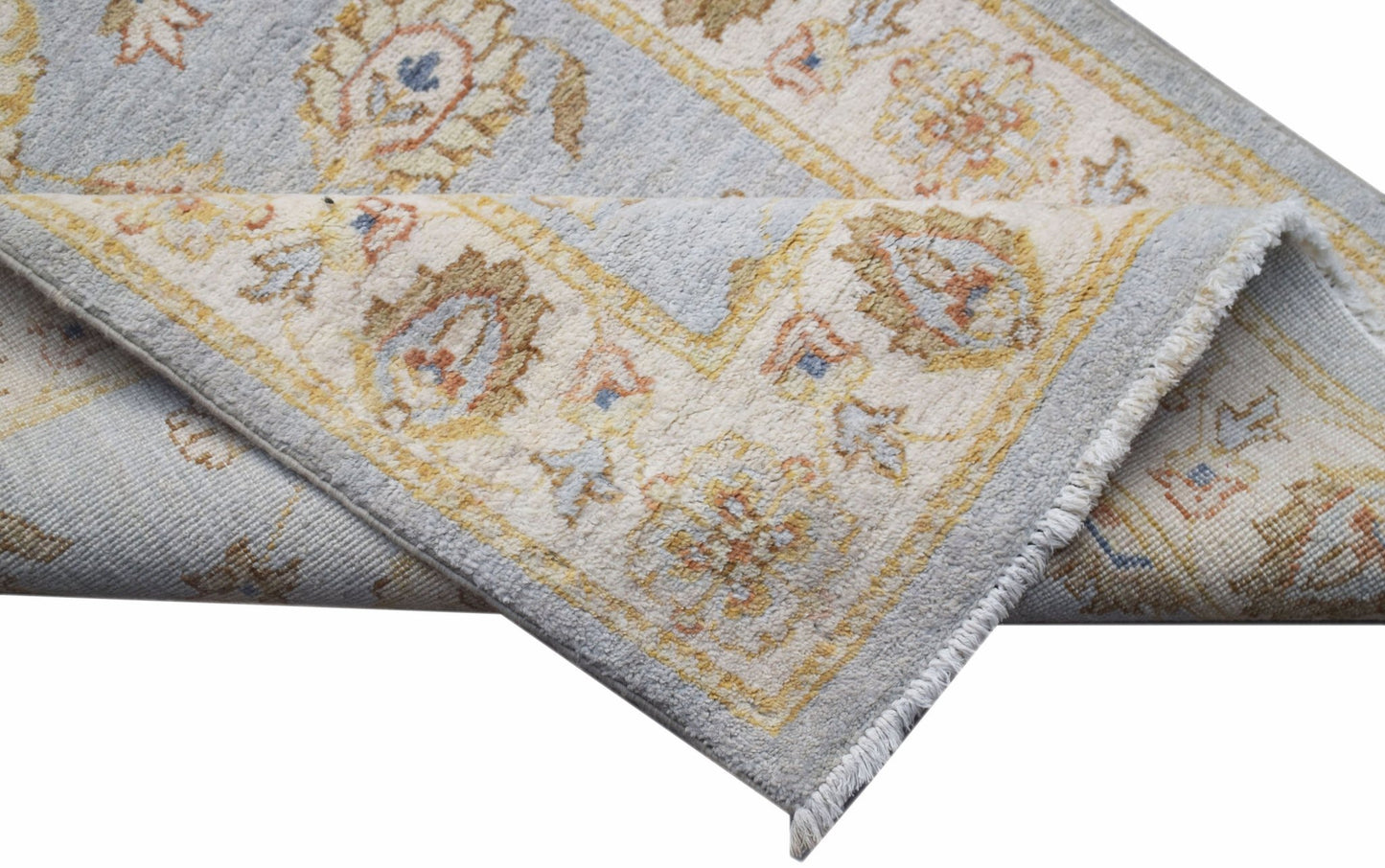 A handwoven Afghan Chobi runner featuring traditional floral patterns in soft blue and beige tones.