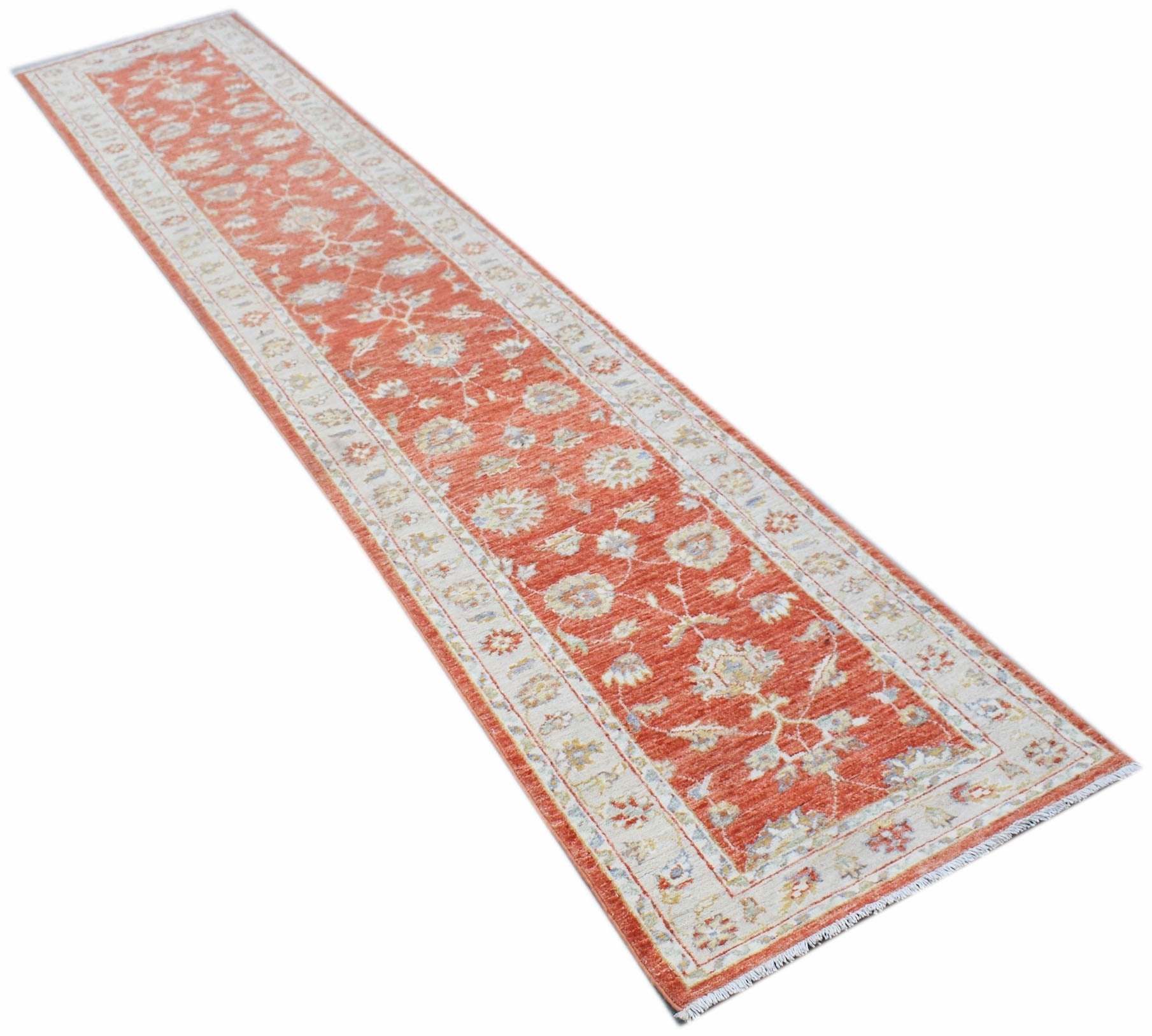 A handmade Afghan Chobi runner rug featuring a traditional floral pattern in shades of red and cream.