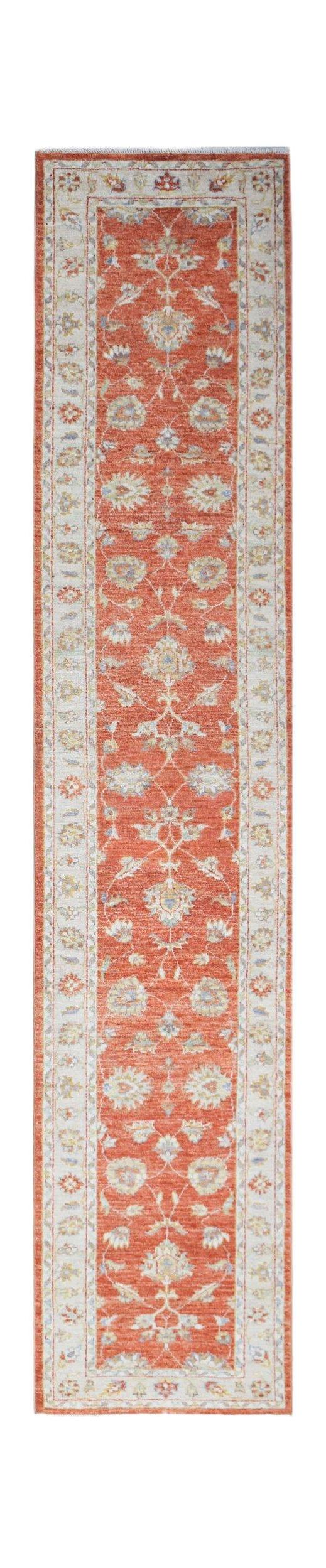 A handmade Afghan Chobi runner rug featuring a traditional floral pattern in shades of orange.