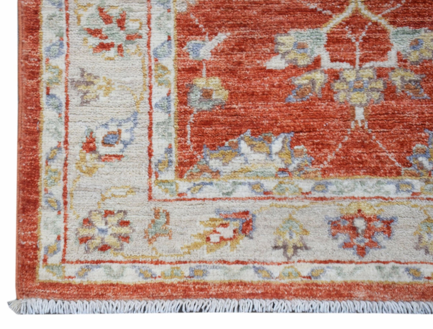 A handmade Afghan Chobi runner featuring a traditional floral pattern in rust and cream tones.