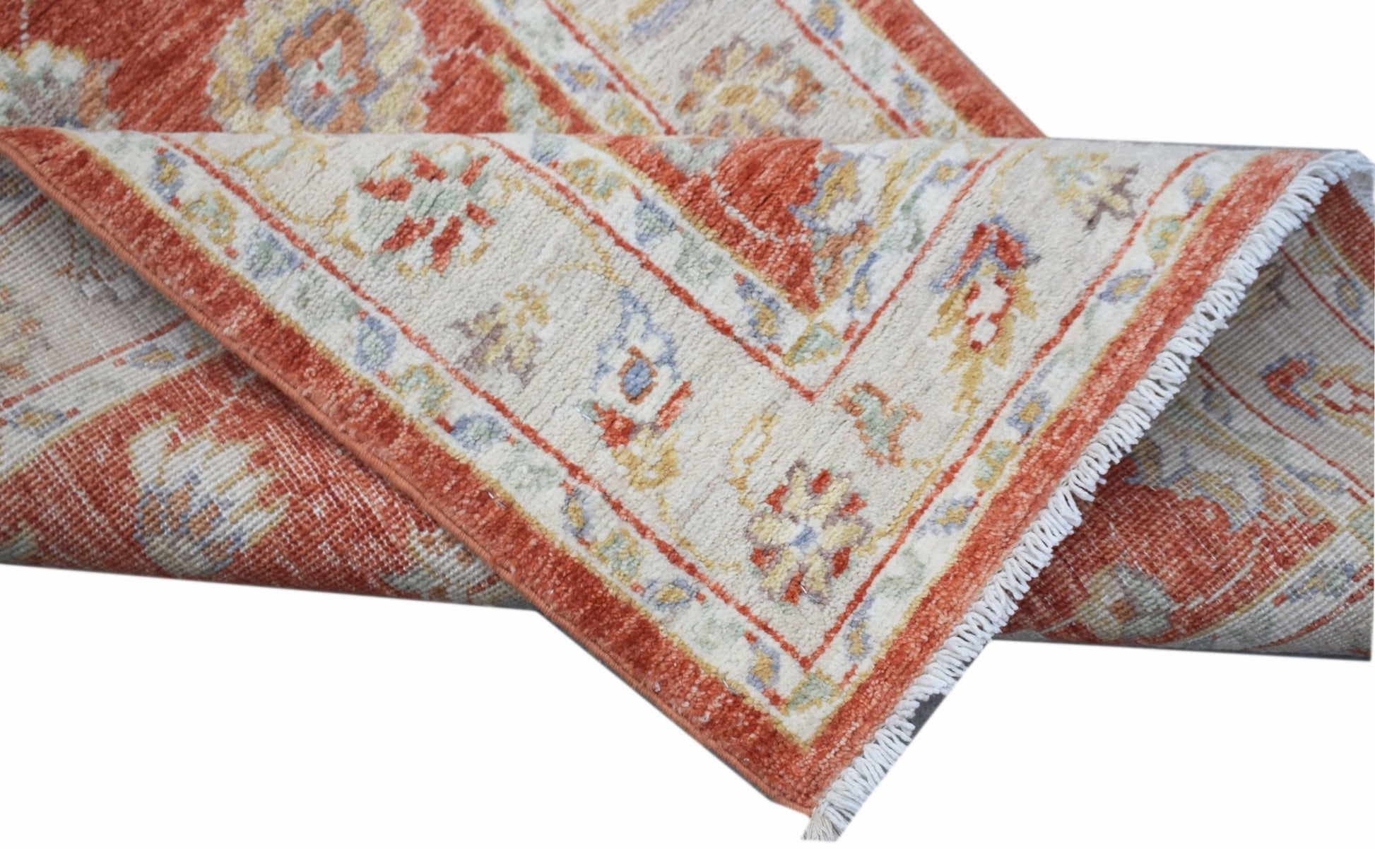 A handwoven Afghan Chobi runner featuring traditional floral patterns in rust and cream tones.