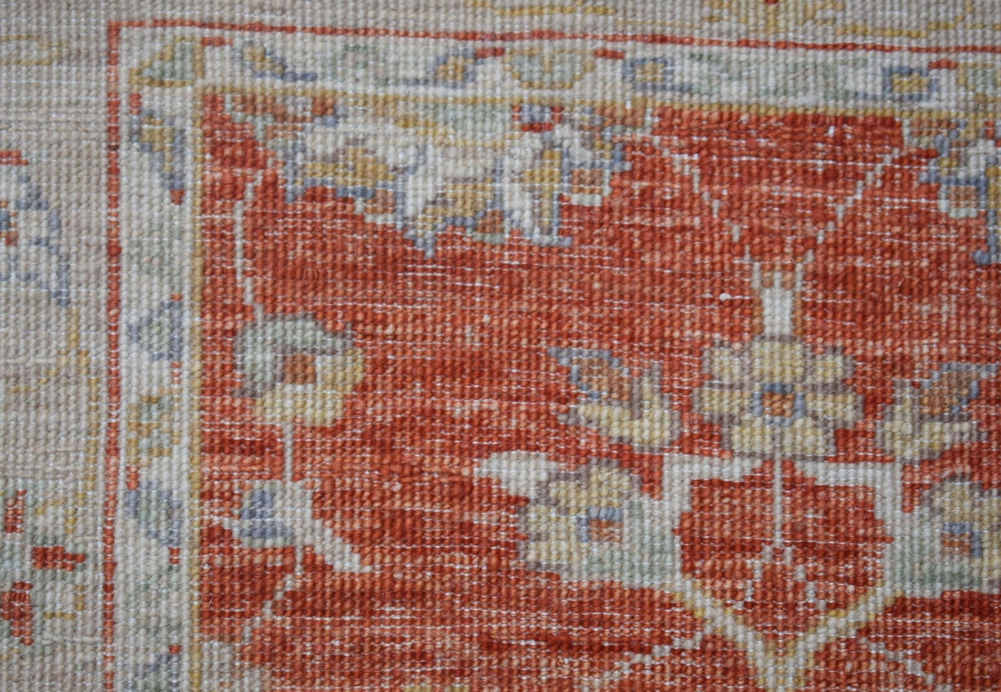 A close-up of an Afghan Chobi runner featuring a traditional floral pattern in rust and cream tones.