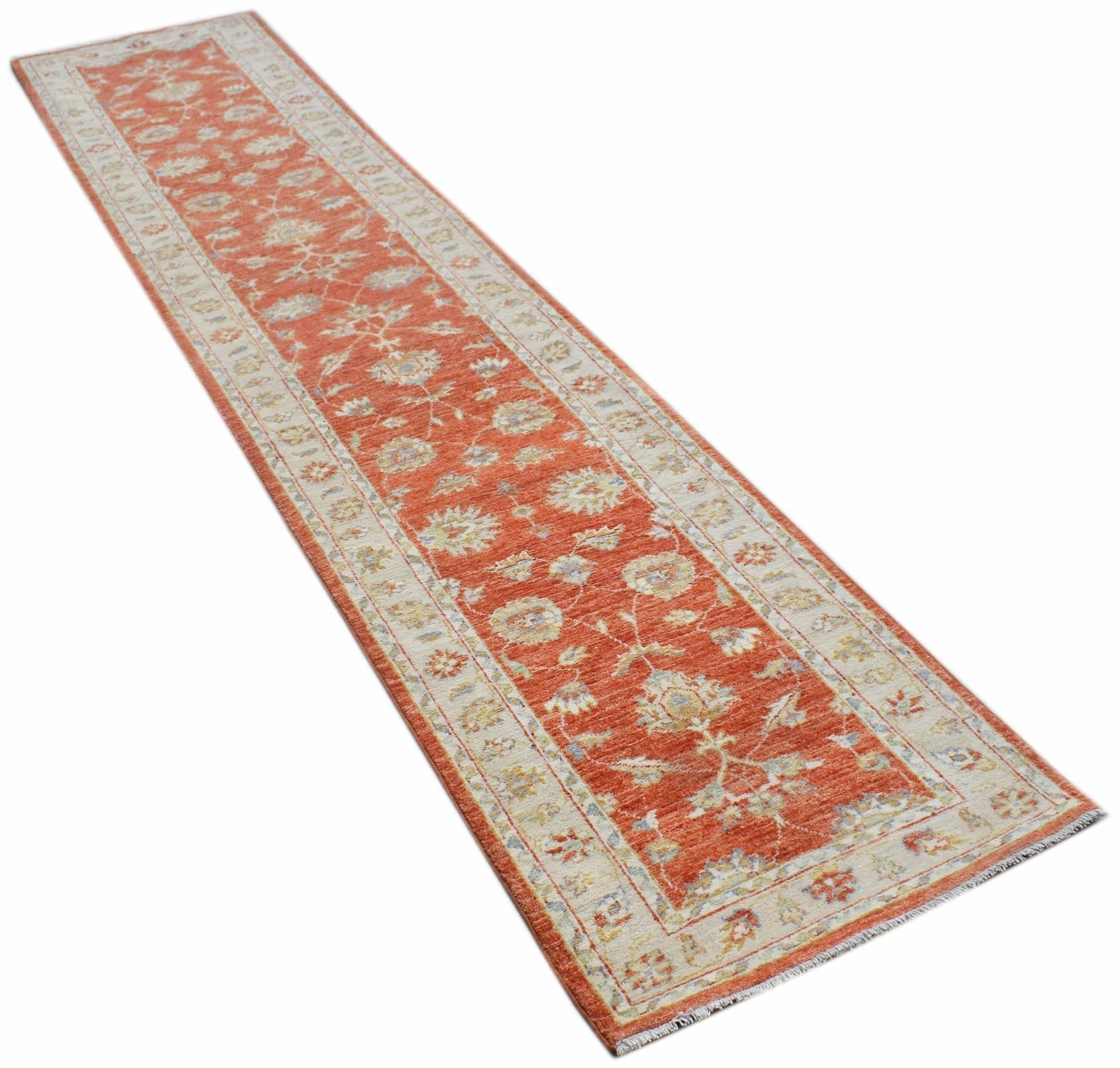 A handmade Afghan Chobi runner rug featuring a traditional floral pattern in orange and cream.