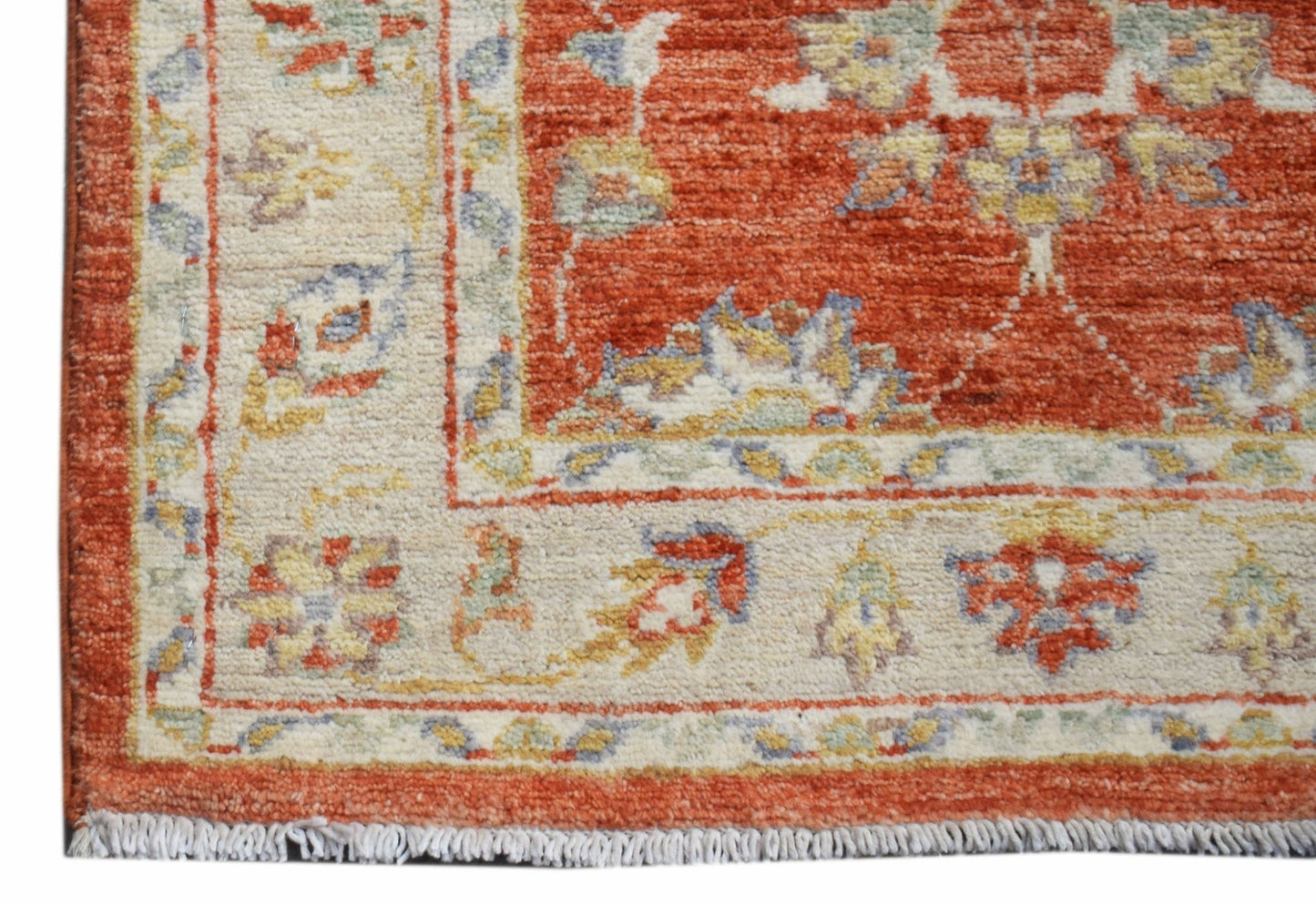 A handwoven Afghan Chobi runner featuring a traditional floral pattern in rust and cream tones.