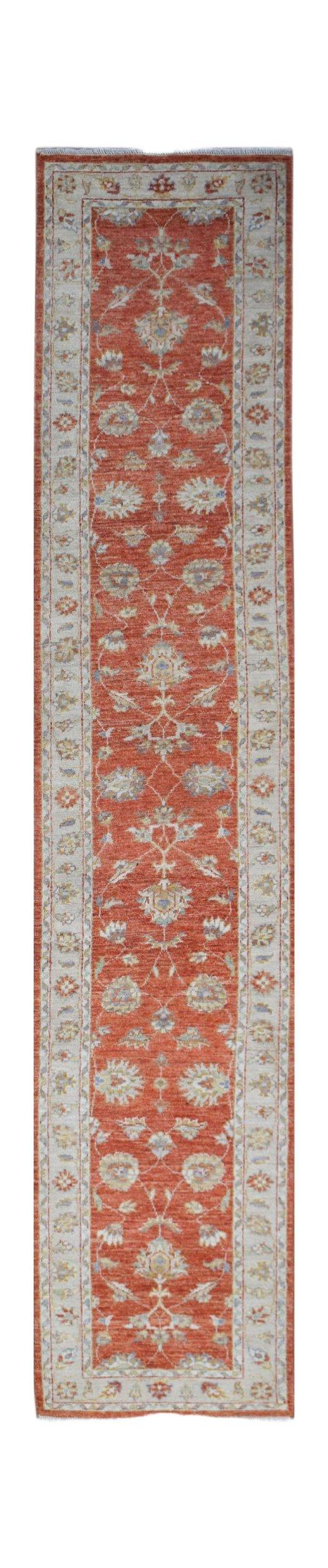 A handwoven Afghan Chobi runner rug featuring a floral pattern in shades of terracotta and cream.