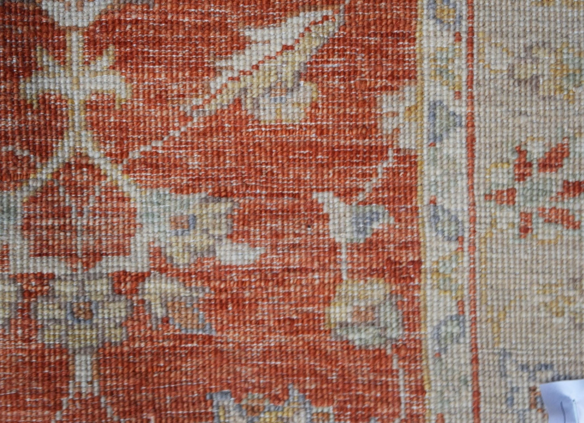 A close-up of an Afghan Chobi runner featuring a traditional floral pattern in rust and cream tones.