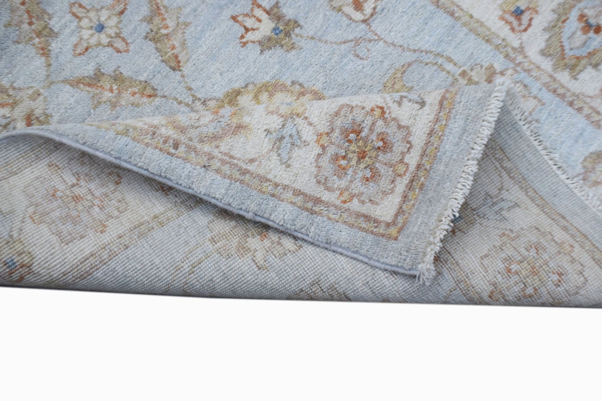 A handwoven Afghan Chobi runner featuring a light blue field with traditional floral patterns.