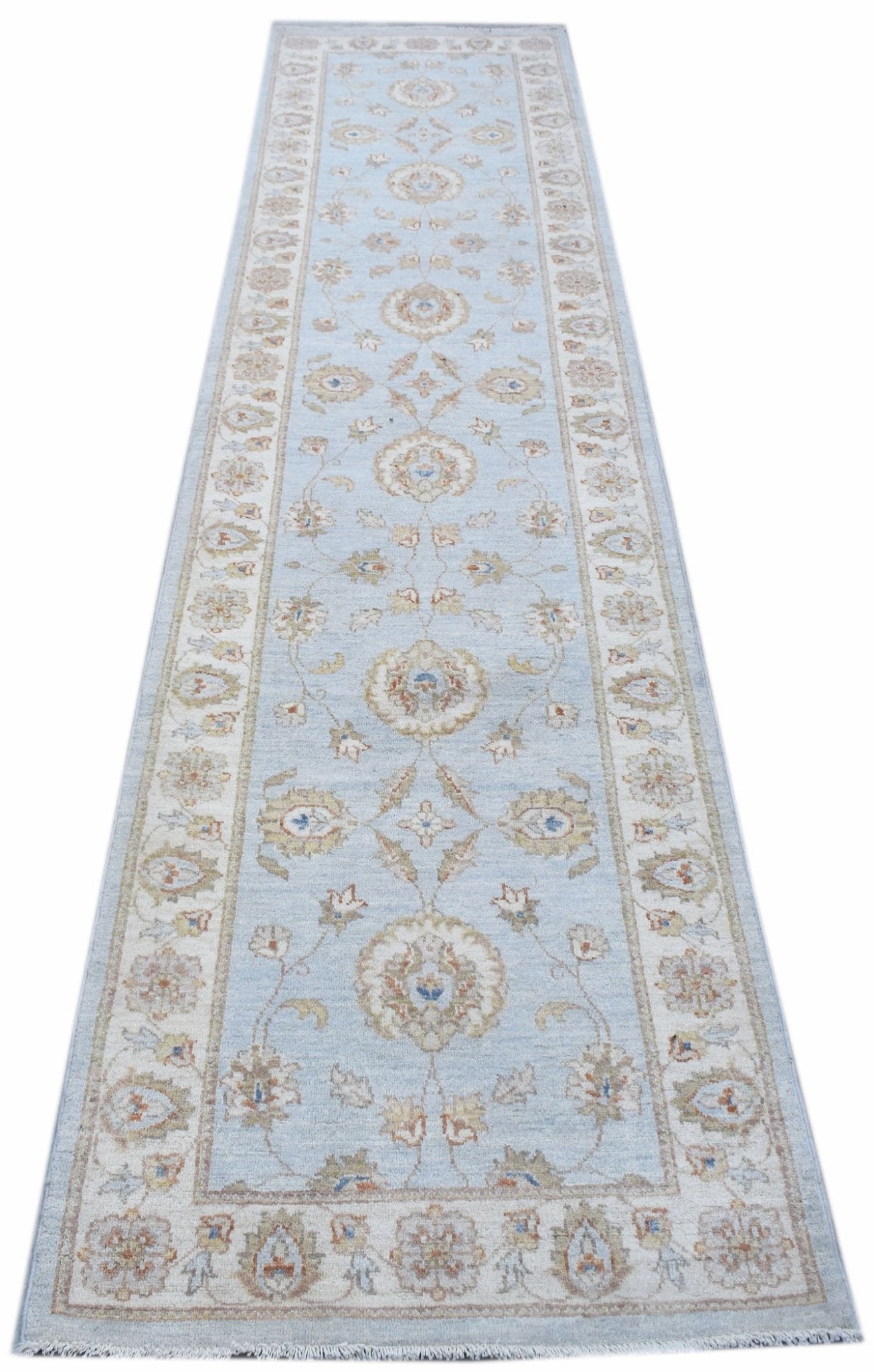 A handmade Afghan Chobi runner rug featuring a traditional floral pattern in soft blue and beige.