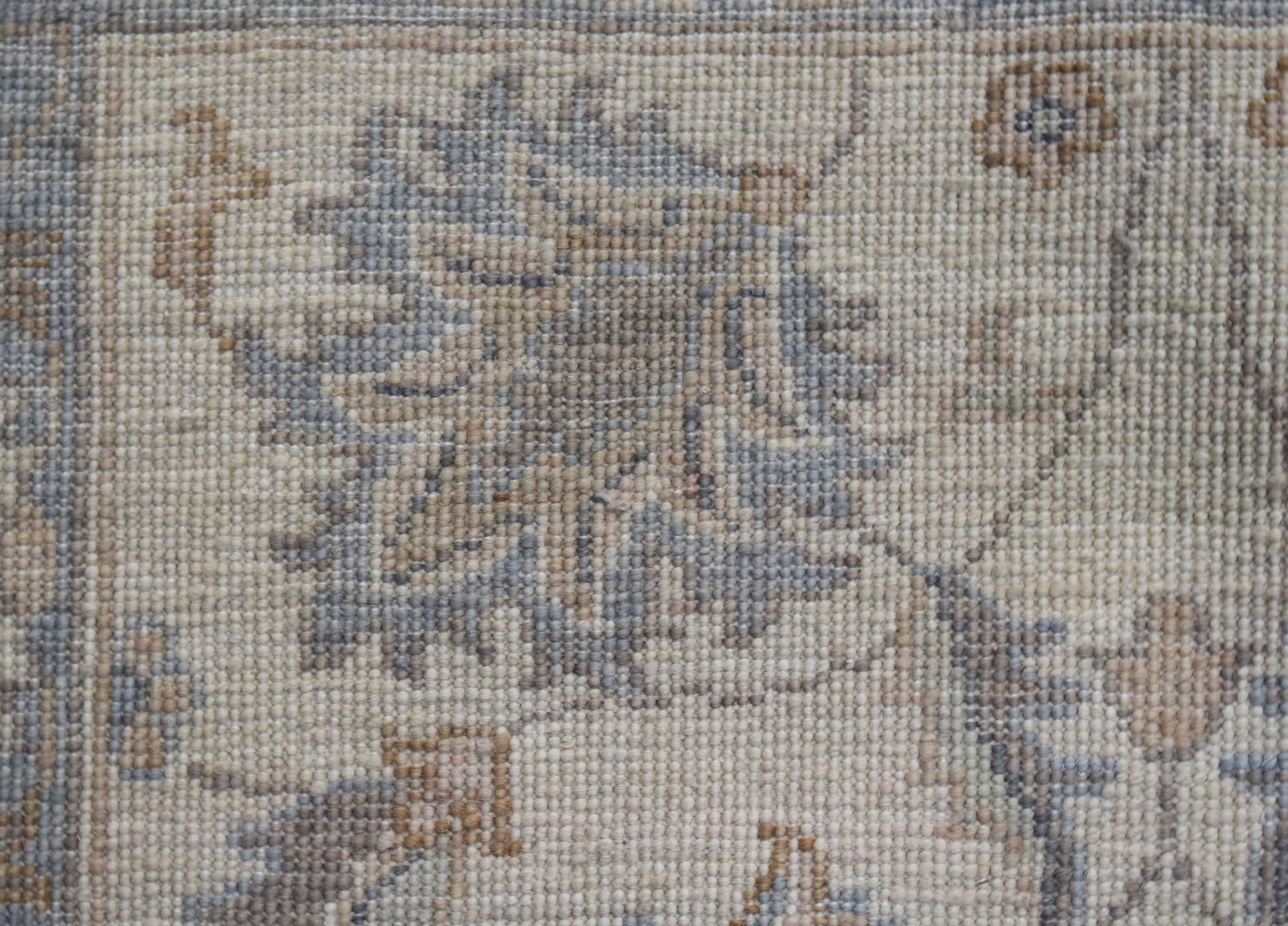 A close-up of a handwoven Afghan Chobi runner featuring intricate floral patterns in muted tones.