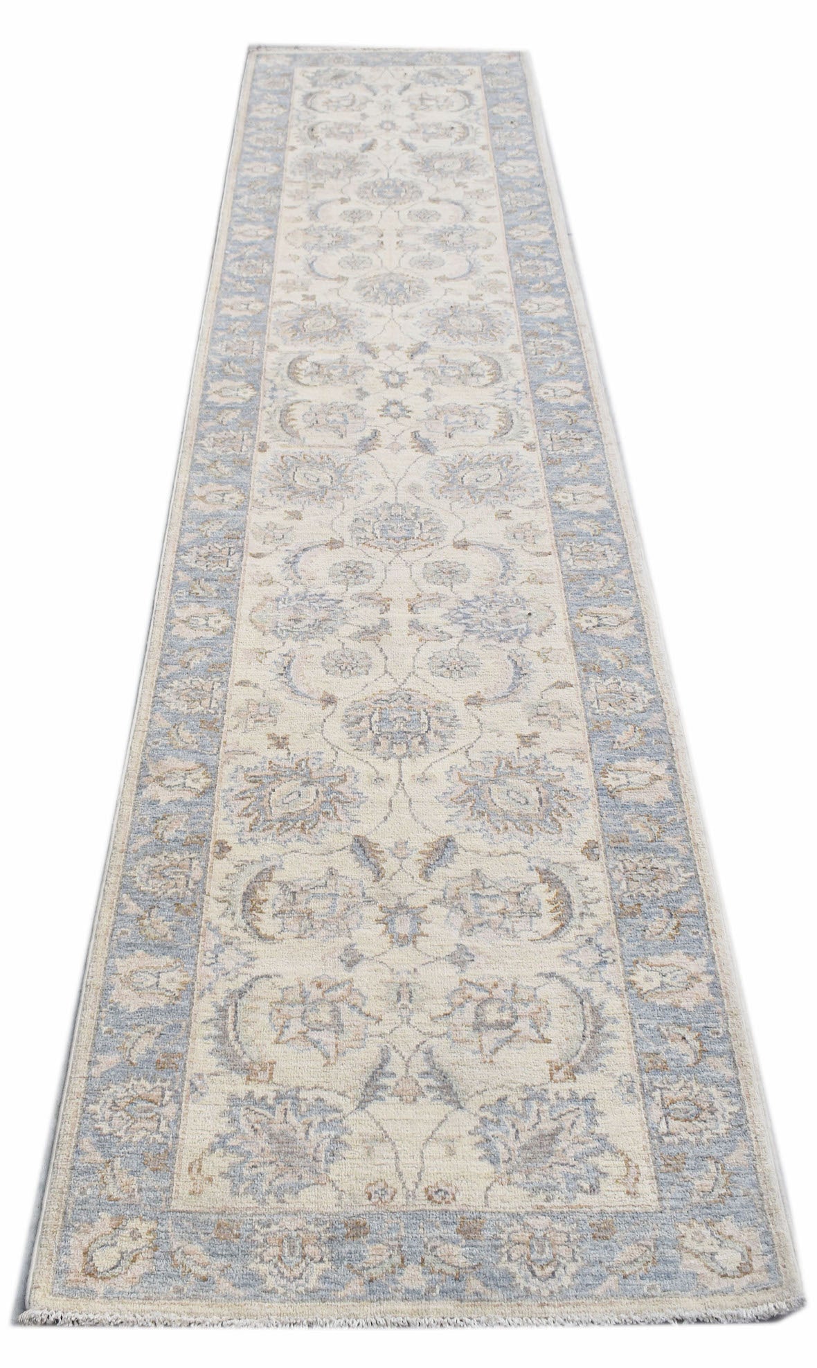 A handmade Afghan Chobi runner rug featuring traditional floral patterns in soft blue and cream.