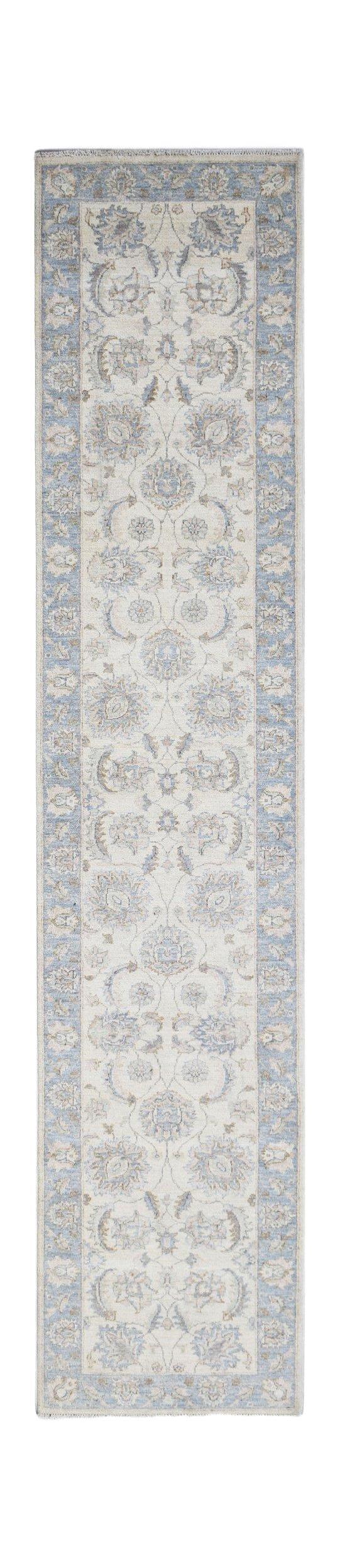 An Afghan Chobi runner rug featuring a traditional floral pattern in soft blue and beige tones.