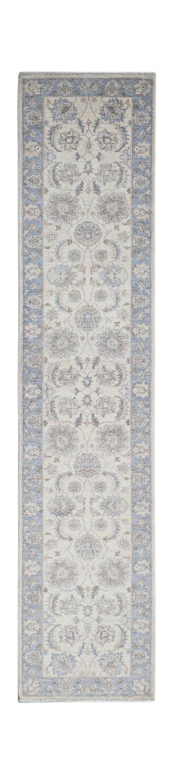 A handmade Afghan Chobi runner rug featuring a traditional floral pattern in blue and cream tones.