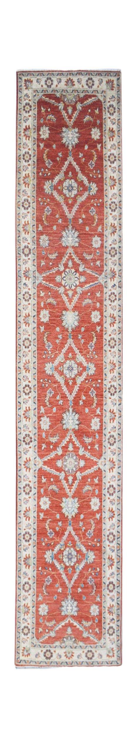 A long, handwoven Afghan Chobi runner rug featuring a traditional floral pattern in red and cream.