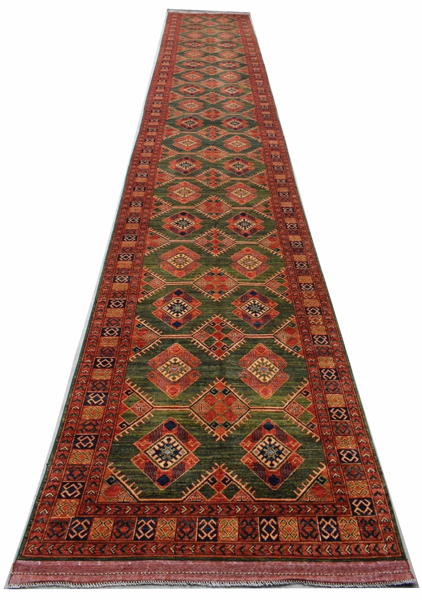 A long, handwoven Afghan Chobi runner rug featuring a repeating diamond pattern in earthy tones.