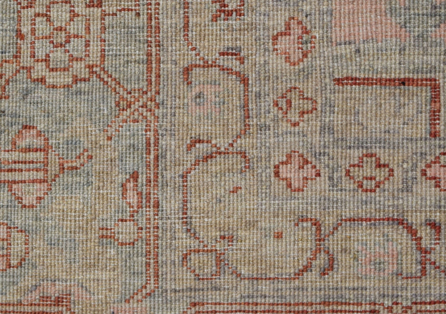A close-up of a handwoven Afghan Chobi rug featuring traditional Heriz patterns in muted tones.