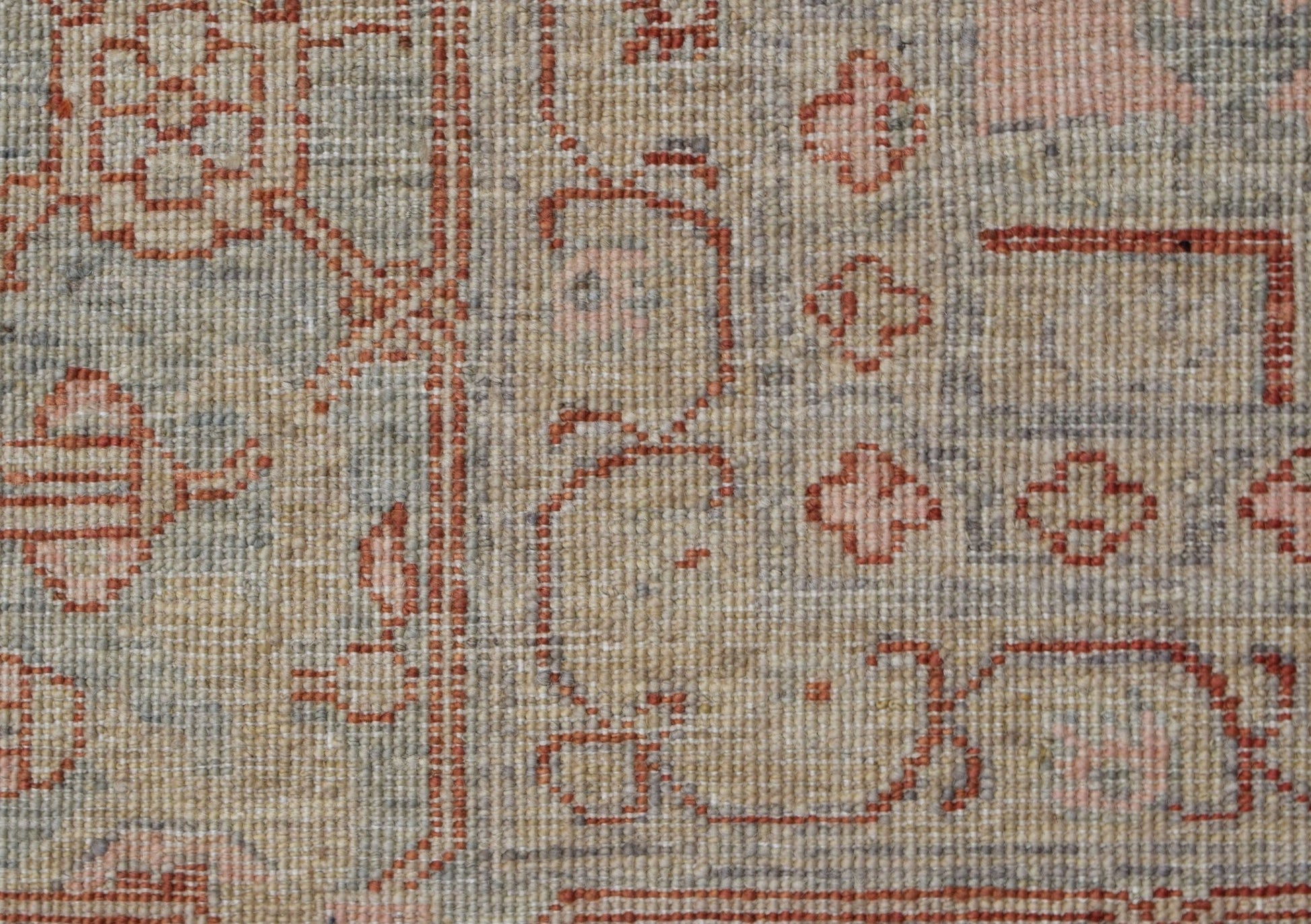 A close-up of a handwoven Afghan Chobi rug featuring traditional Heriz patterns in muted tones.