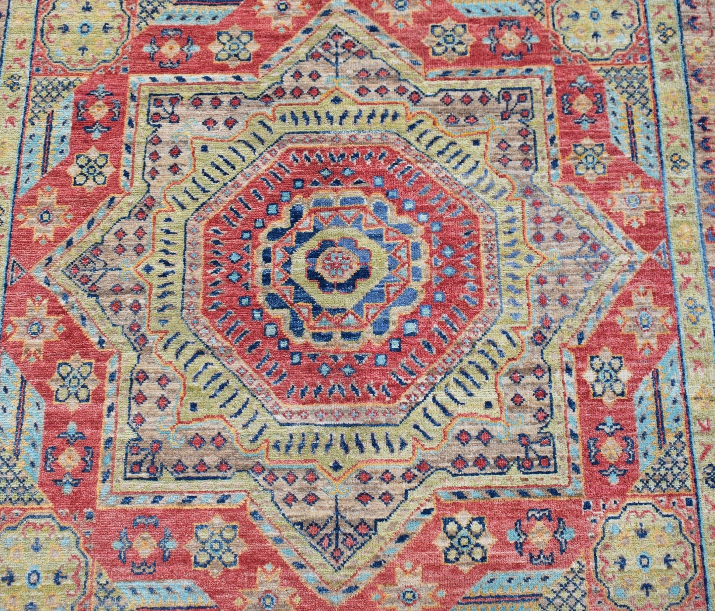 Handwoven Afghan Chobi rug featuring a detailed Mamluk medallion pattern in red, blue, and tan.