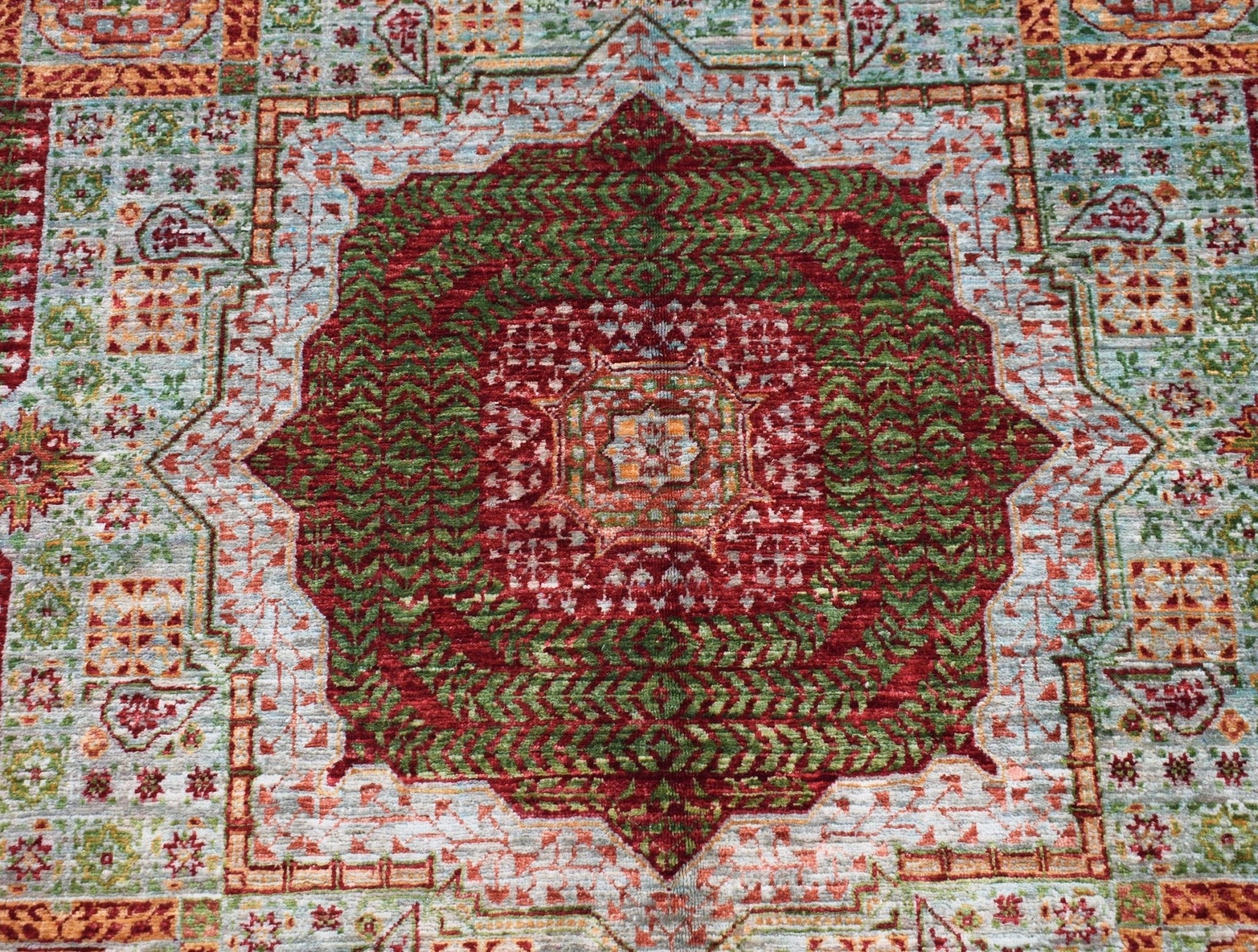 Handwoven Afghan Chobi rug featuring a detailed red and green Mamluk medallion pattern.