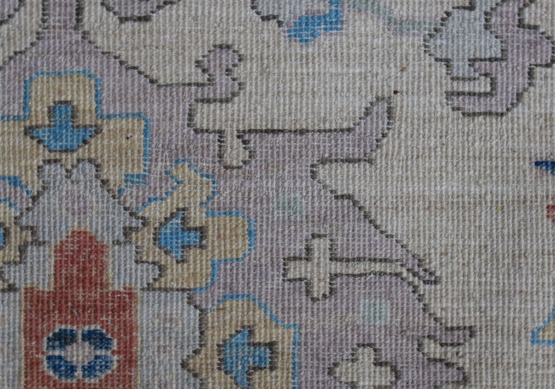 A close-up of a handwoven Afghan Chobi rug featuring traditional geometric patterns in muted tones.