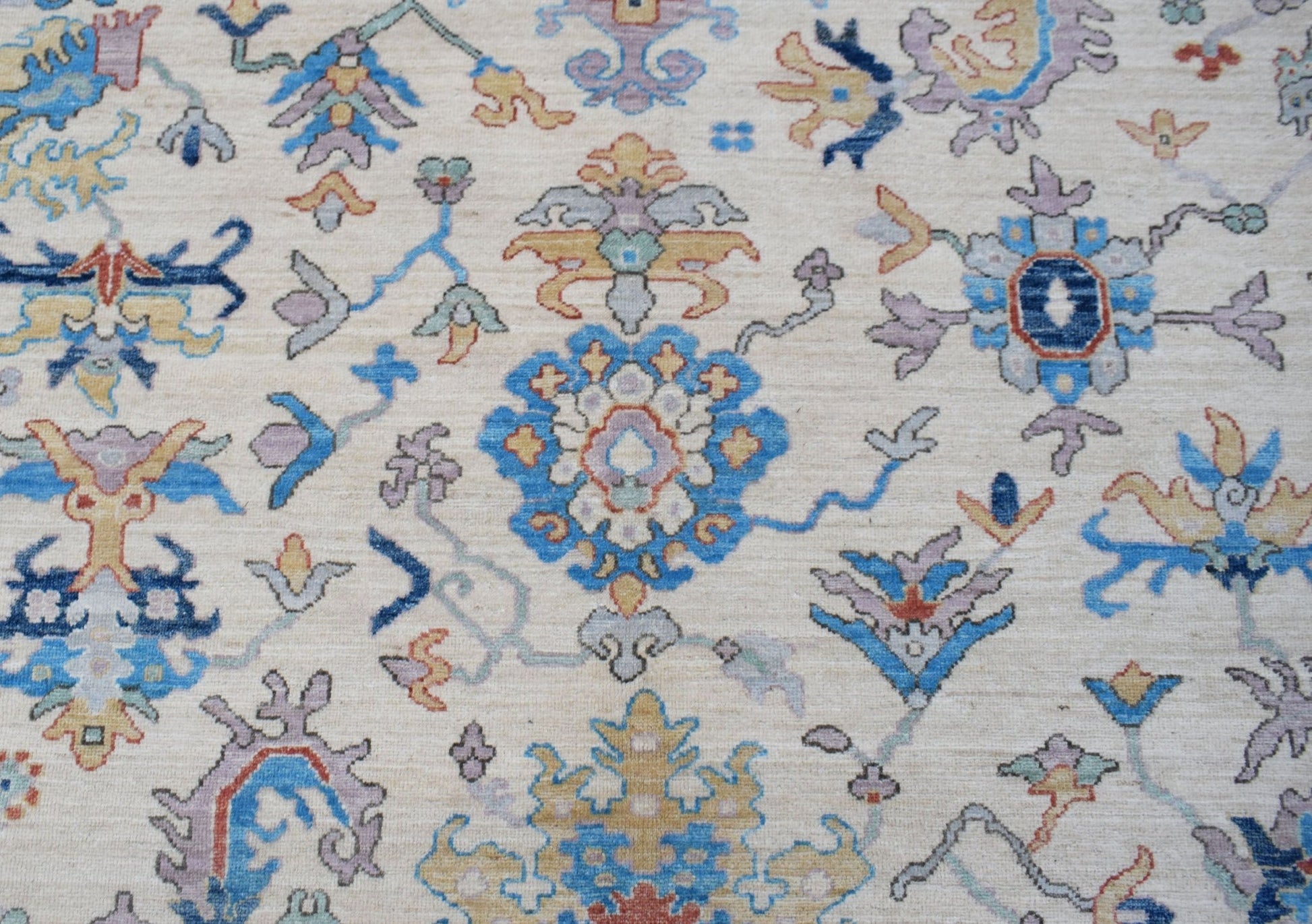 A handmade Afghan Chobi rug featuring a traditional floral pattern in blue, gold, and cream tones.