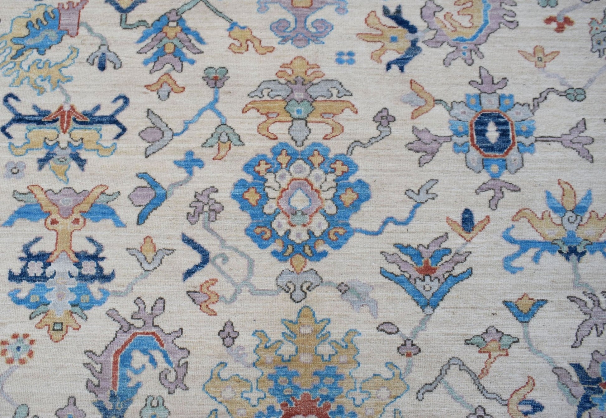 An Afghan Chobi rug featuring a traditional floral pattern in blue, gold, and cream tones.