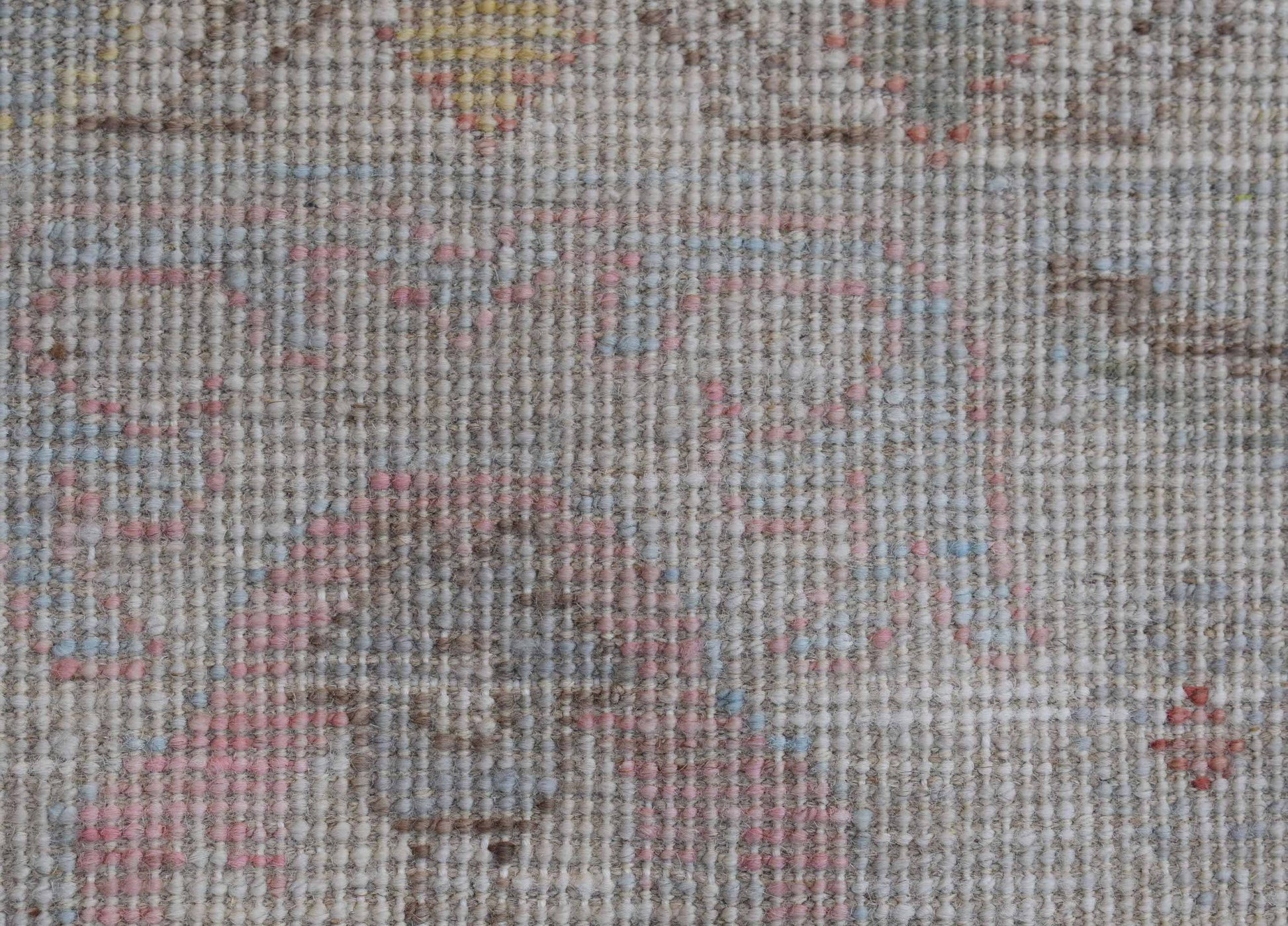 A close-up view of a transitional Oushak rug featuring a soft, floral pattern in muted tones.
