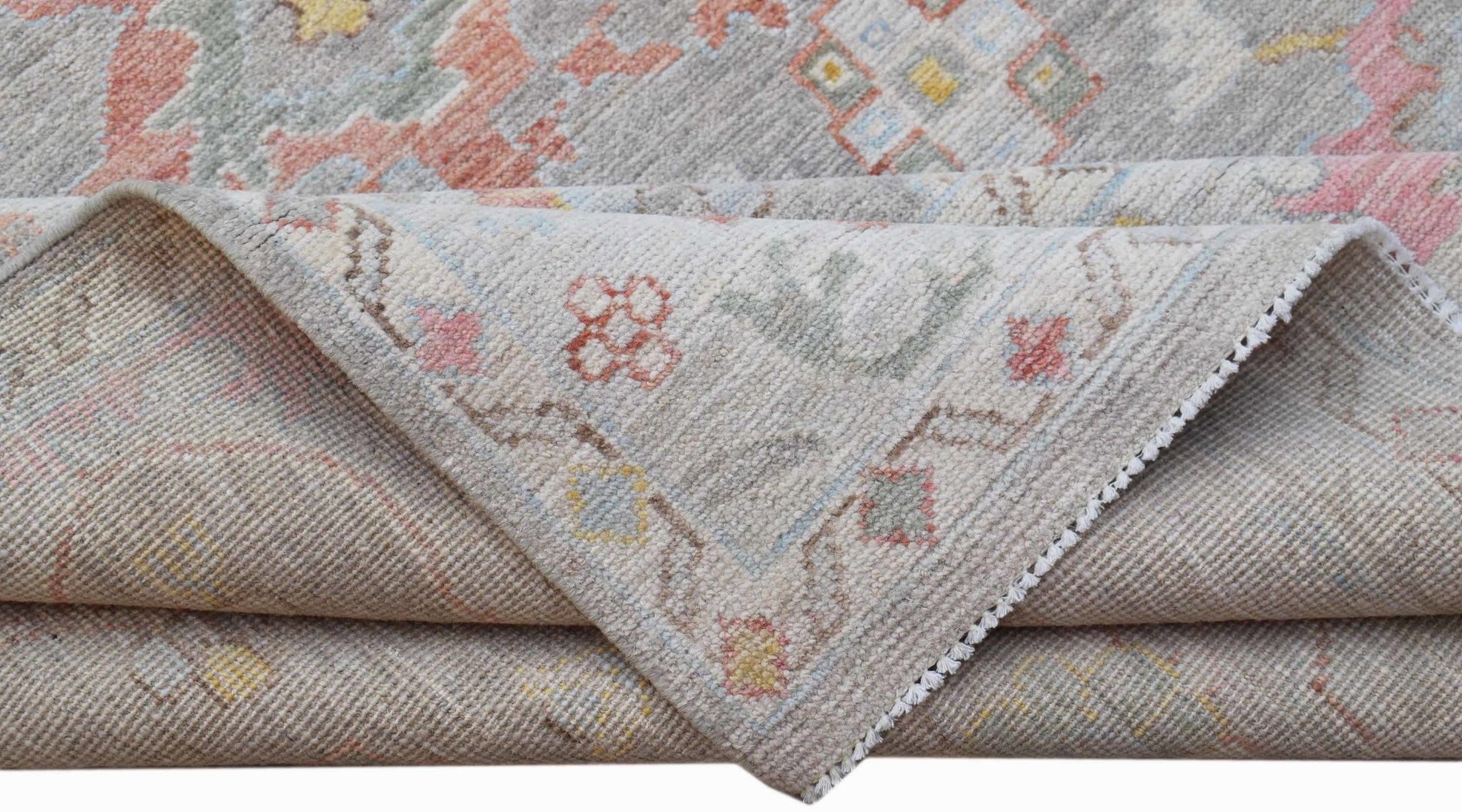 A handwoven transitional Oushak rug featuring a floral pattern in soft, muted tones.