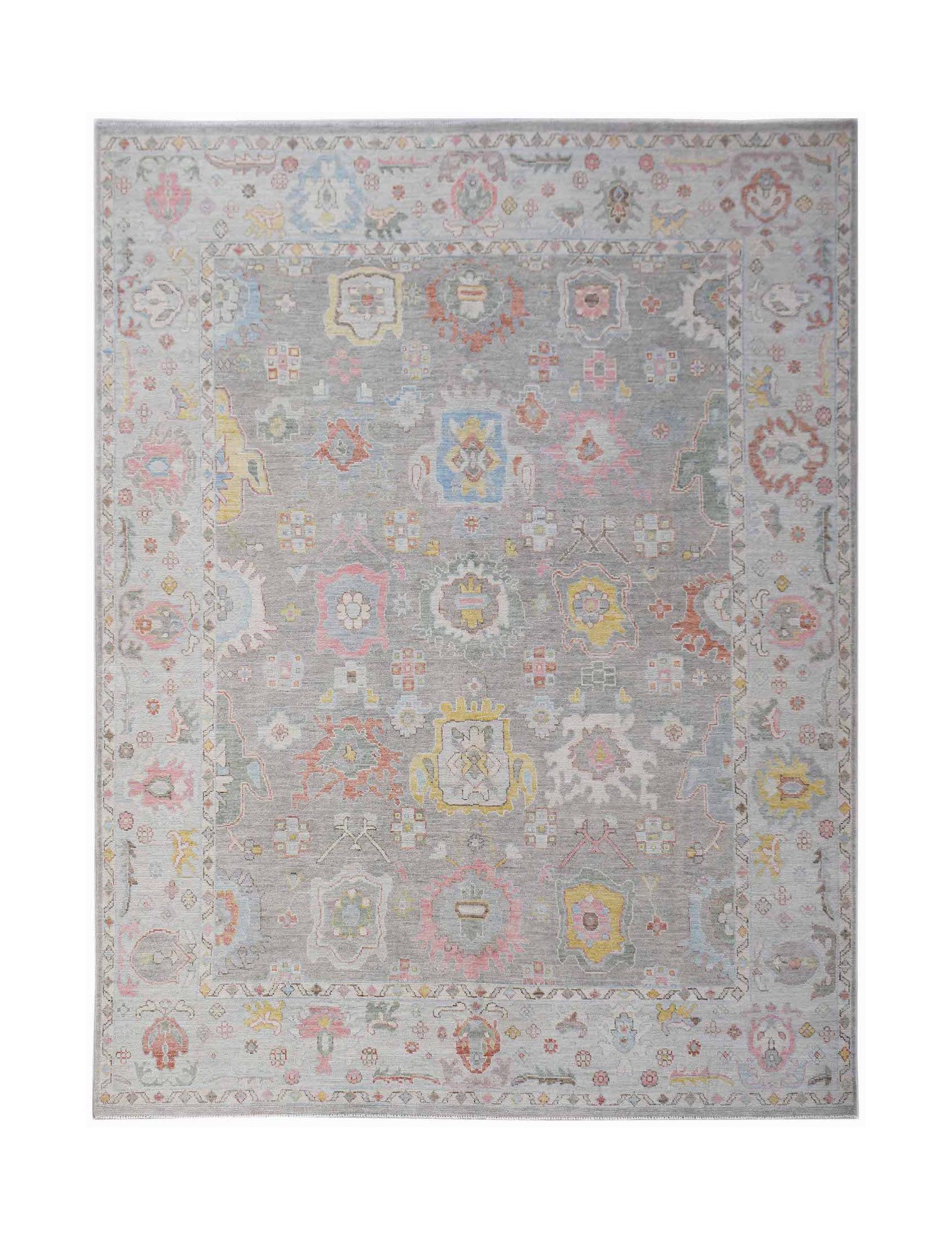 A transitional Oushak rug featuring a grey field with colorful floral motifs and a patterned border.